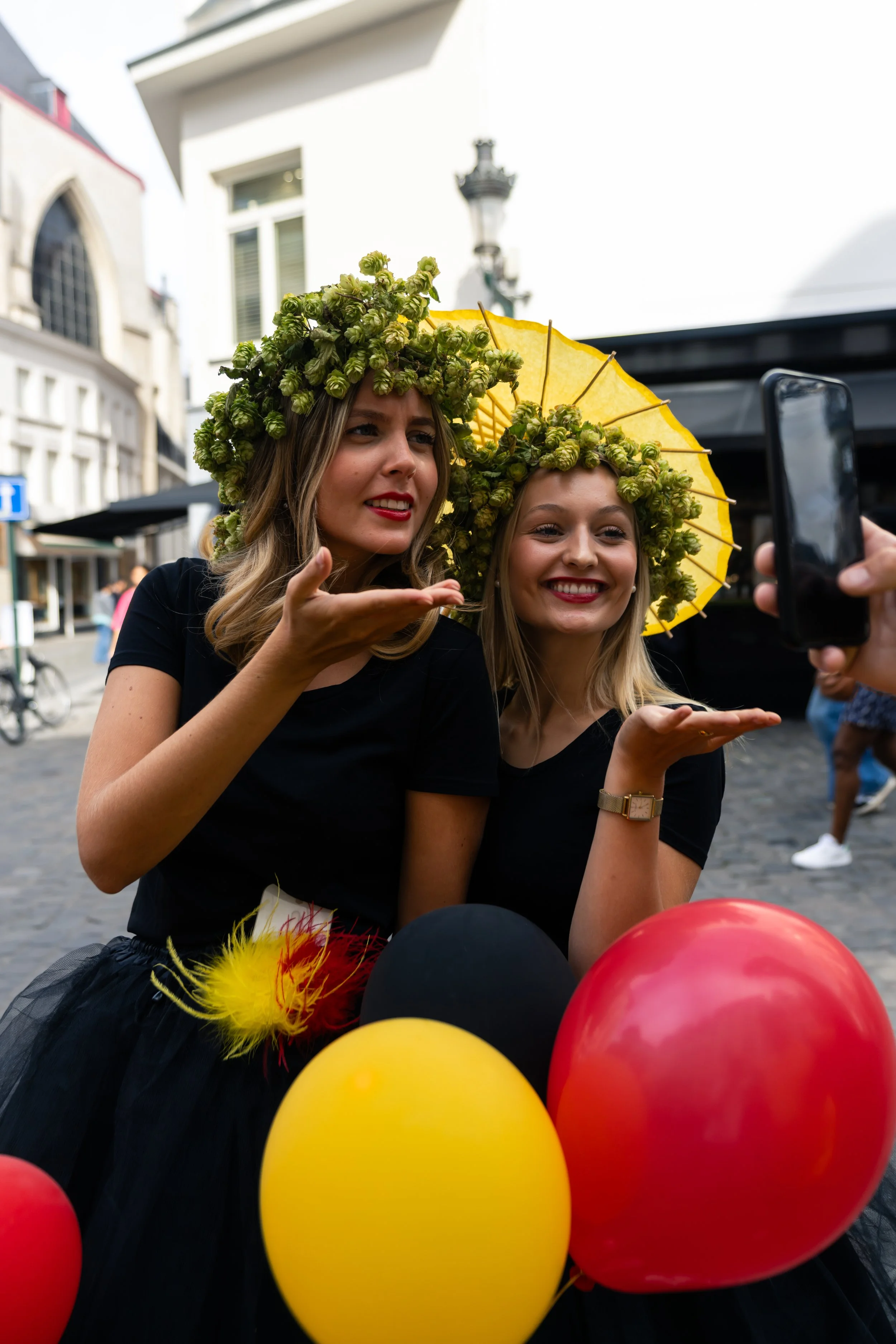 Twee jonge vrouwen met een bloemenkrans proosten met een speciaalbier op het Belgian Beer Culture Days festival in Brussel.
