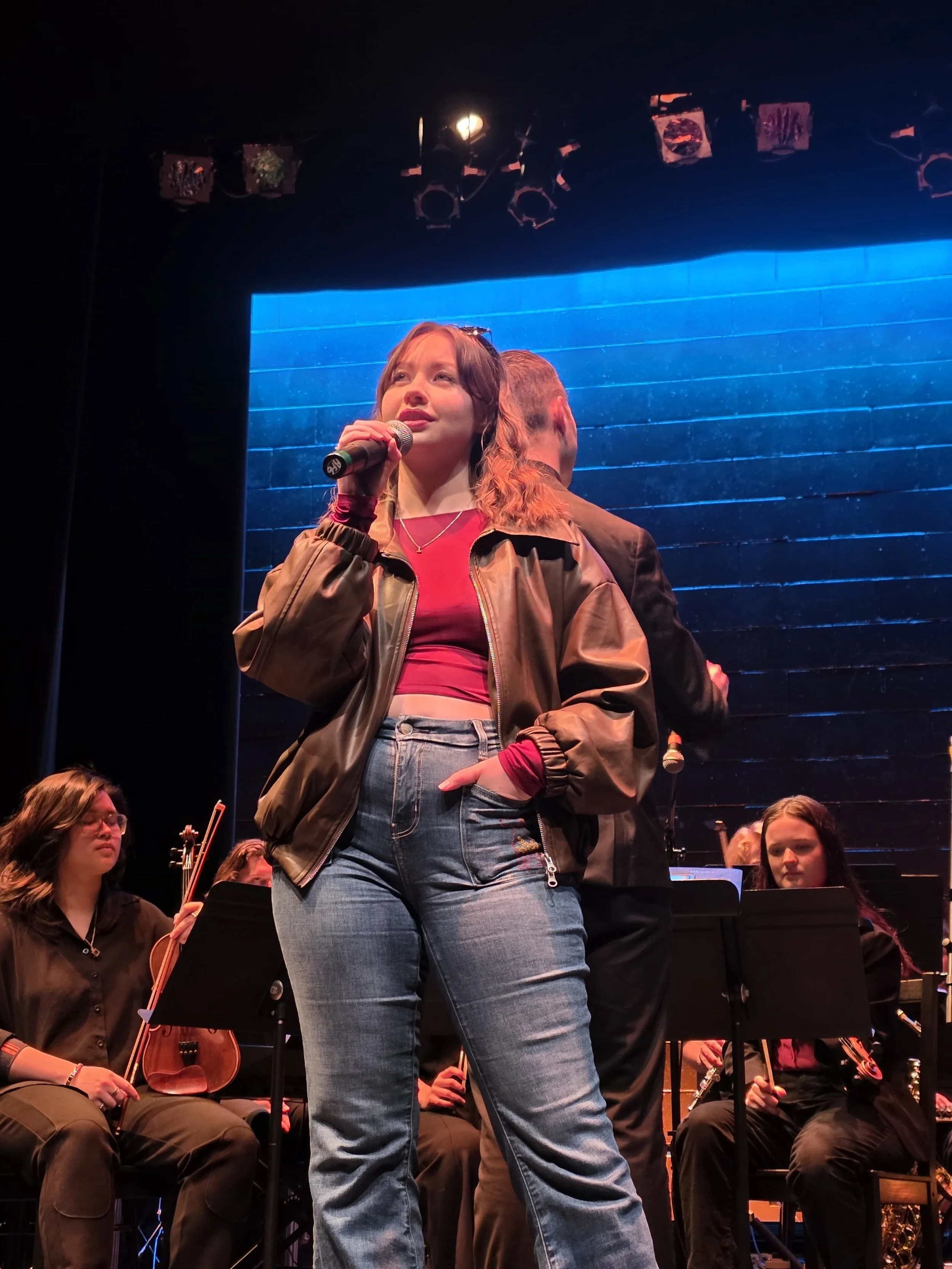 Amie Wren in front of a pit orchestra, performing 'Me and the Sky' from 'Come From Away'.