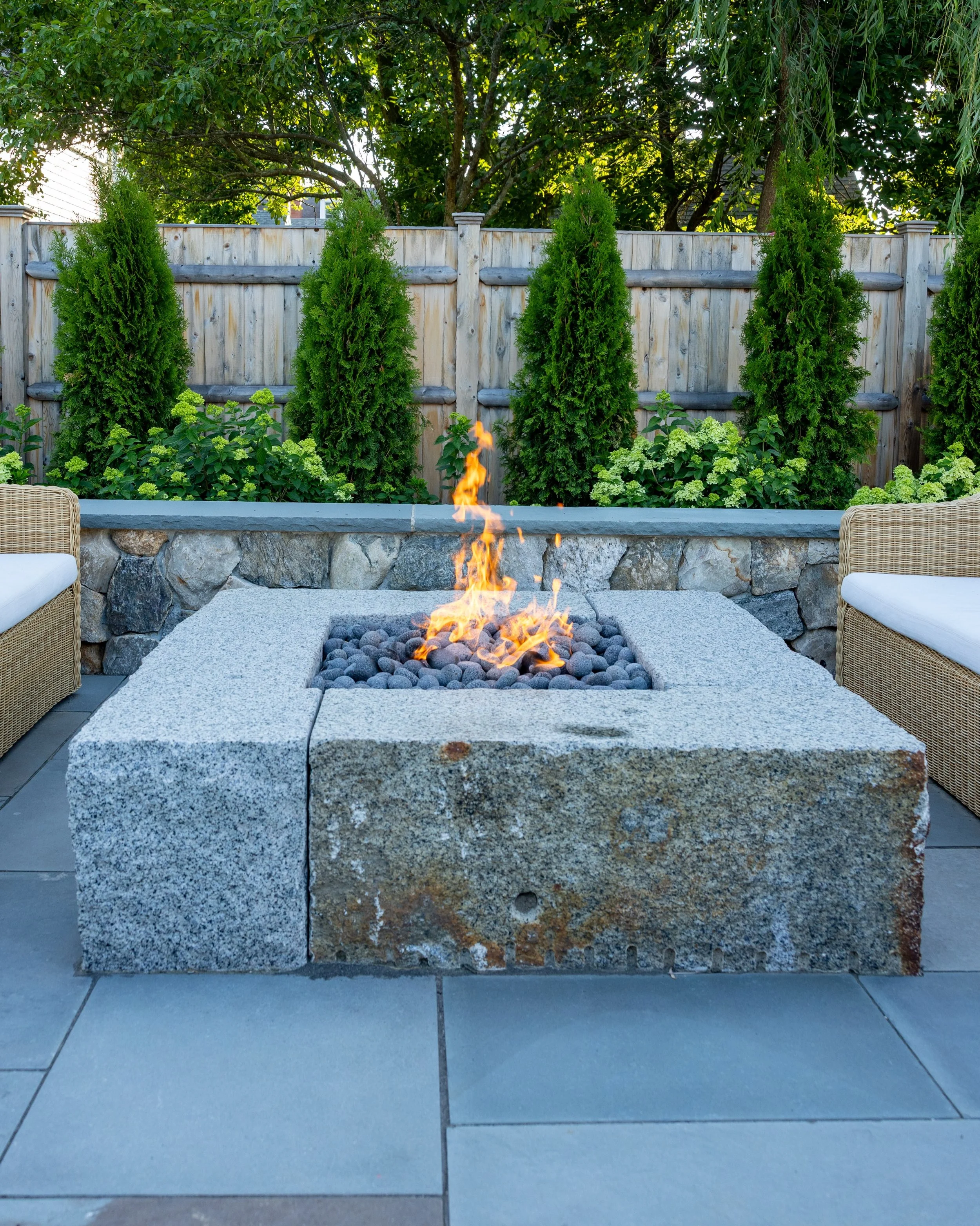 Calling this a &ldquo;firepit&rdquo; would be a serious understatement. Built with 4 massive solid granite blocks carefully lowered into place and set in a Natural Cleft bluestone patio. Flanked by a fieldstone sitting wall with a thermal bluestone c