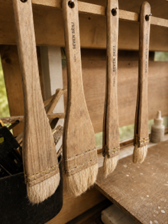 Glazing brushes stored in the pottery studio for applying ceramic glazes.