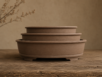 Three handcrafted stoneware oval bonsai pots from the Seasons Restrained collection, show in graduating sizes