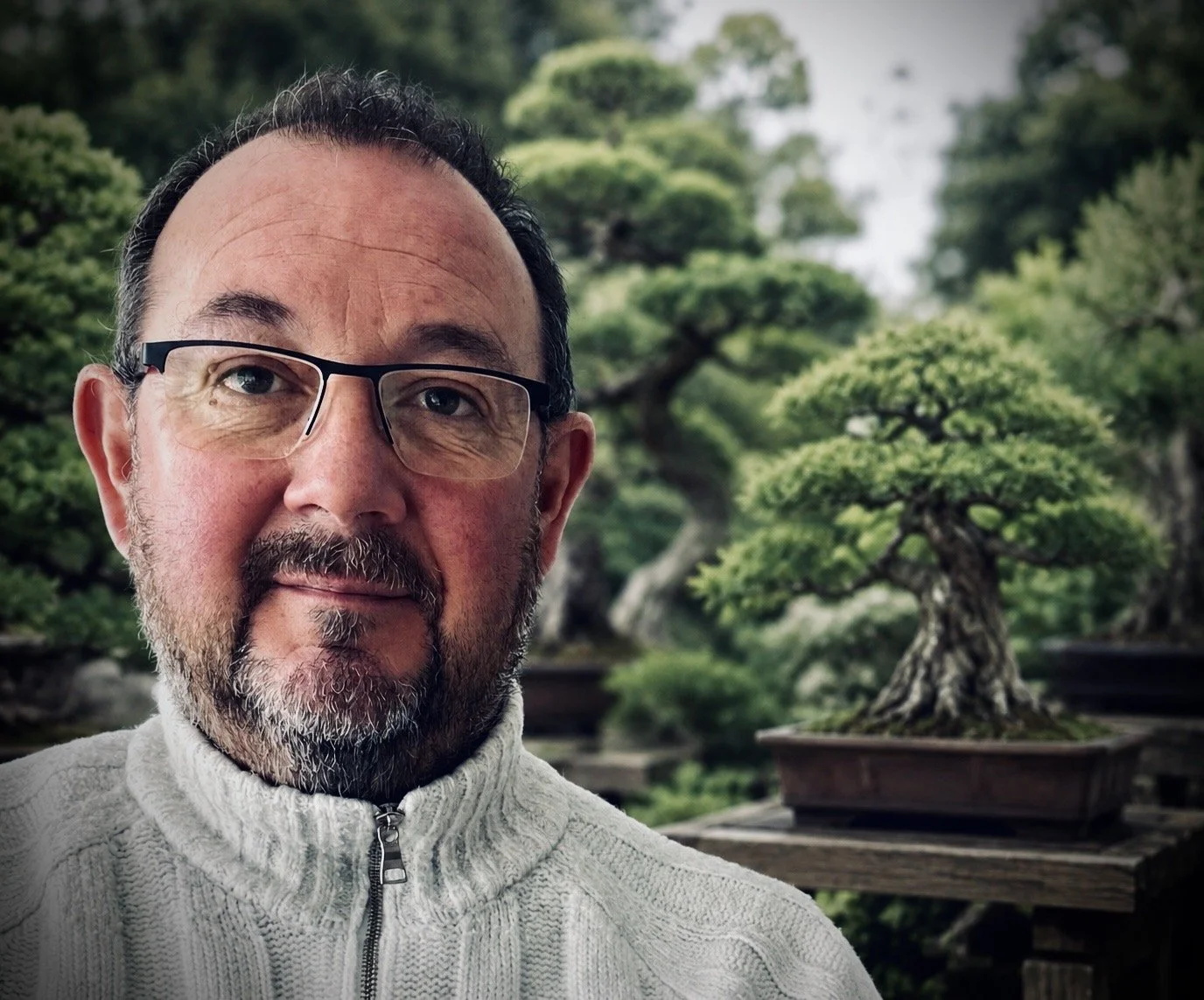 Portrait of the pot maker with a bonsai tree in the background.