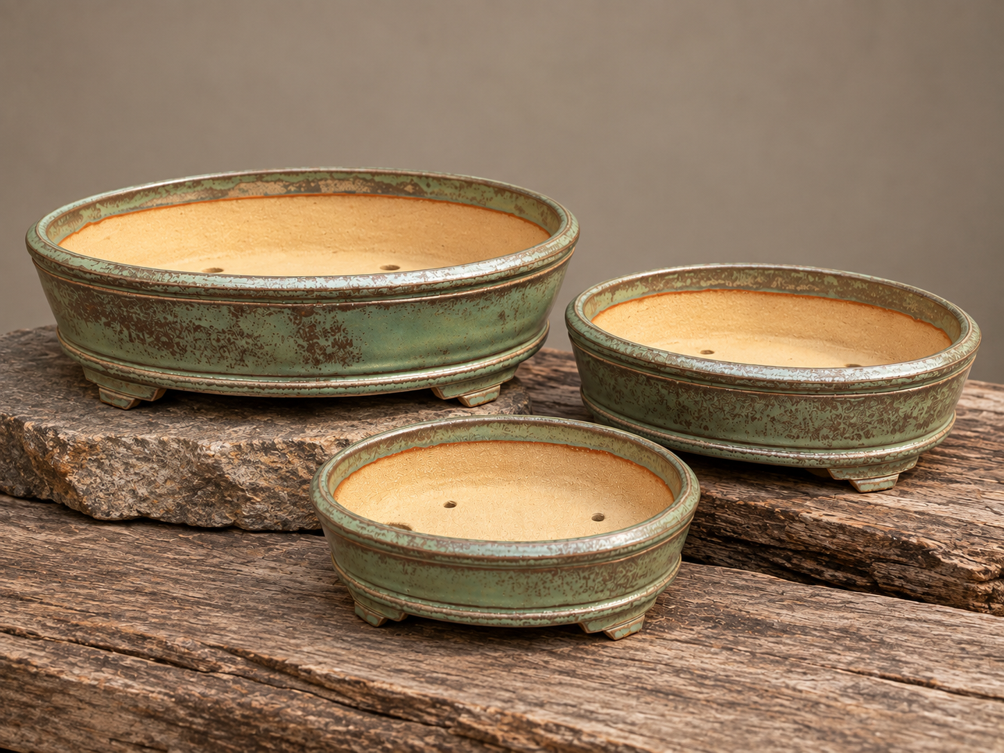Three handcrafted oval bonsai pots from the Seasons Restrained collection, featuring a angled crown in Tree Lichen, by Ian Jobling Ceramics.