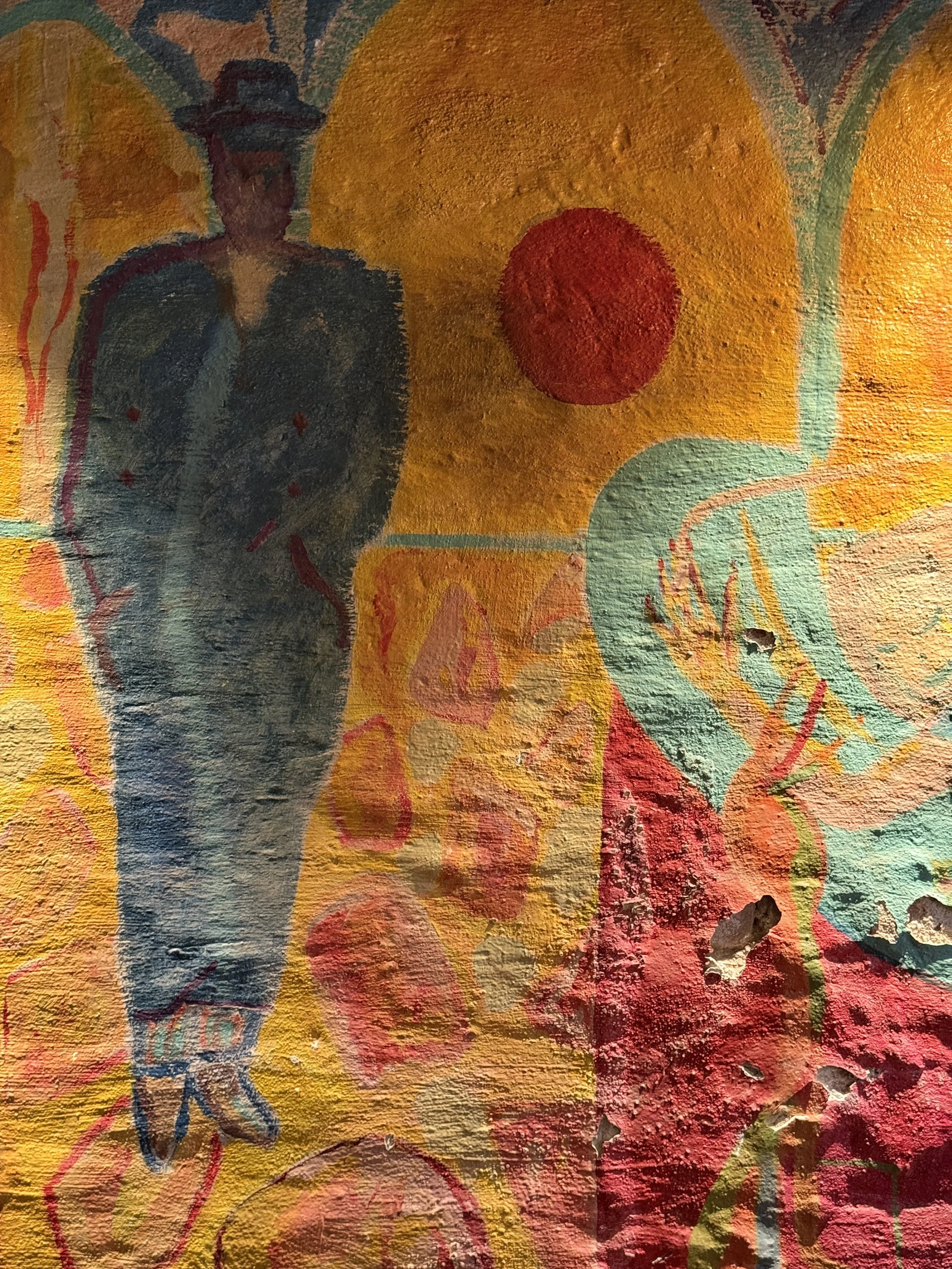 A colorful abstract mural featuring a dark silhouette of a woman wearing a hat, a red circle, large orange and yellow shapes, and various swirling lines and patterns.