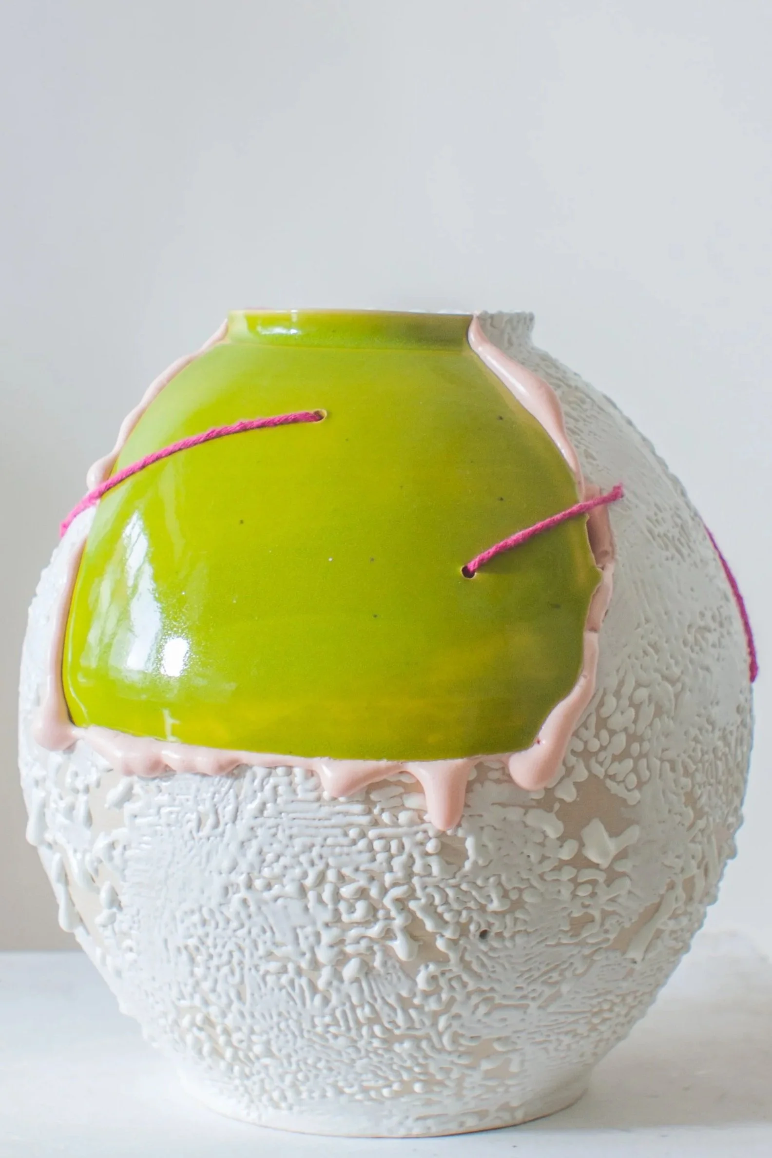 Textured white stoneware vase with a bright lime-green glaze