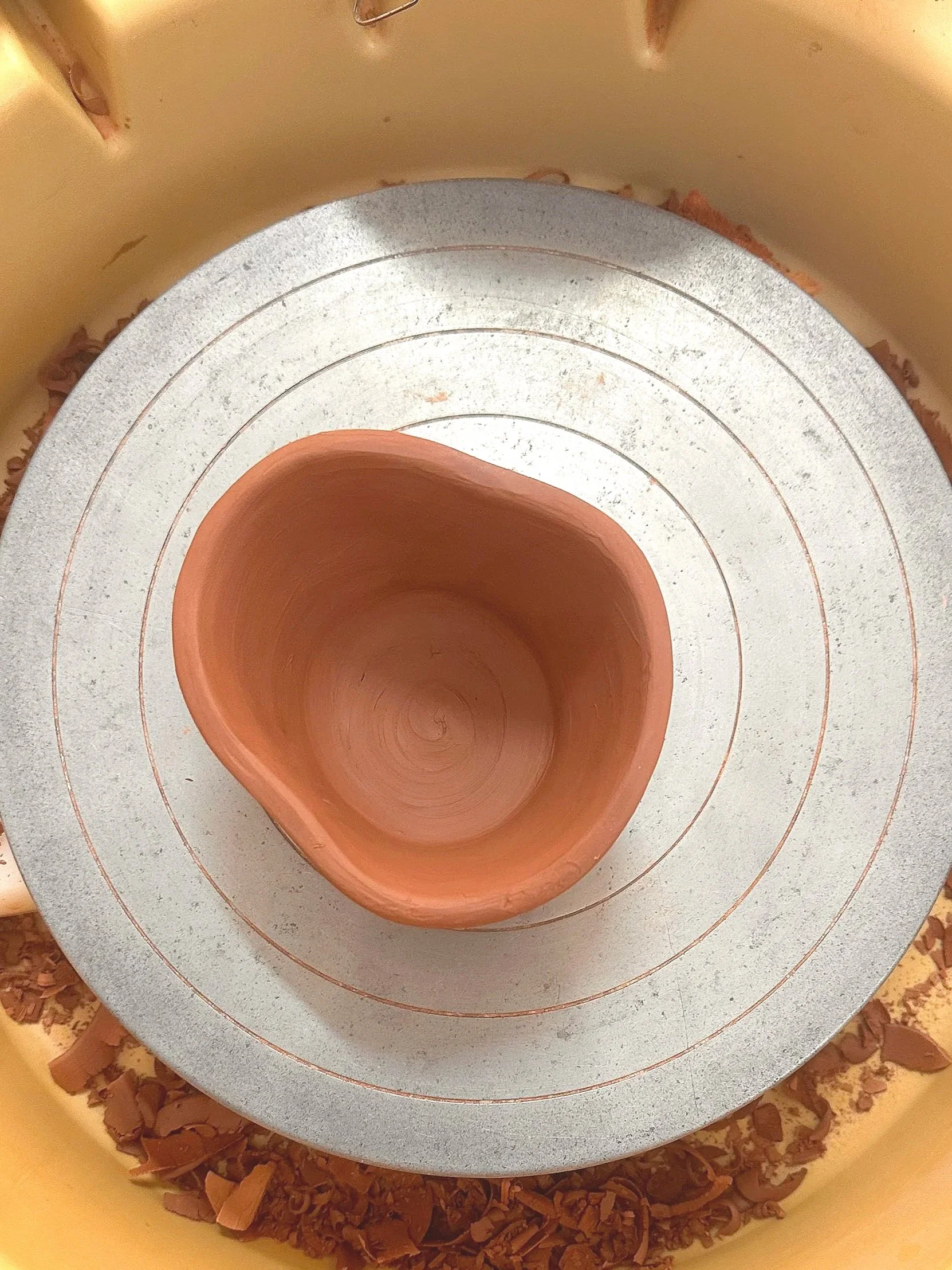Freshly thrown terracotta bowl on the wheel head