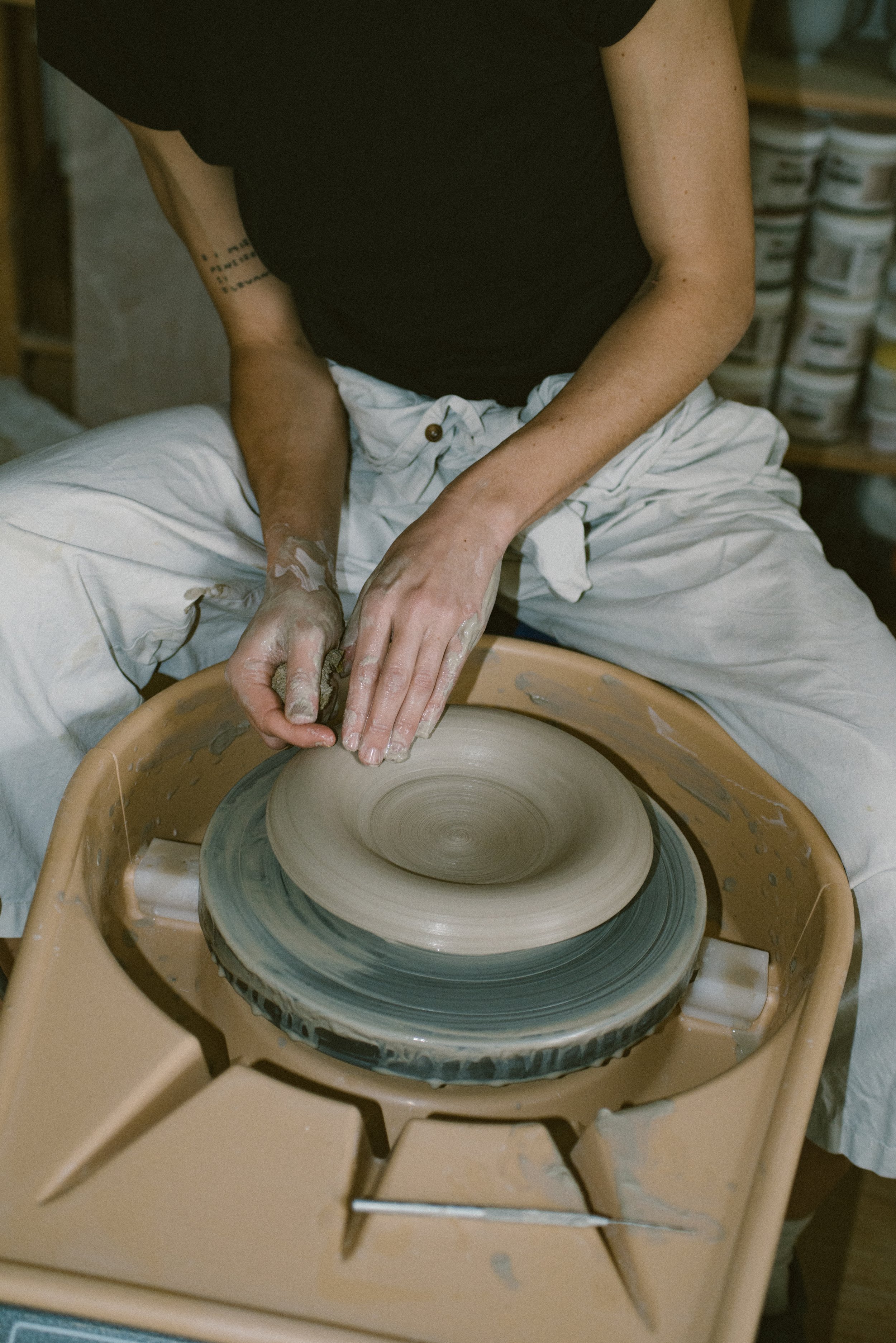 Wheel throwing a bowl, close-up of hands on the clay