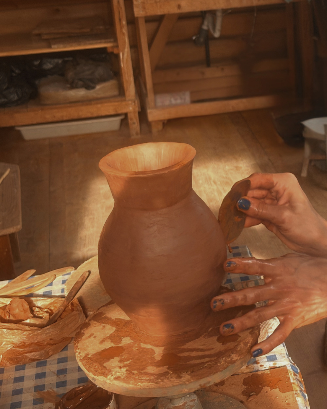 Hands shaping a terracotta vase on the pottery wheel at a ceramics retreat in Portugal