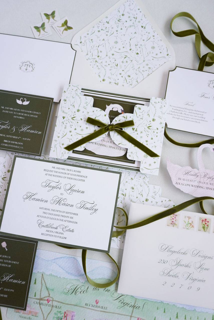 Elegant wedding invitation suite including RSVP card, details card, and a small gift box decorated with a green ribbon, surrounded by floral-themed stationery and butterfly stamps.