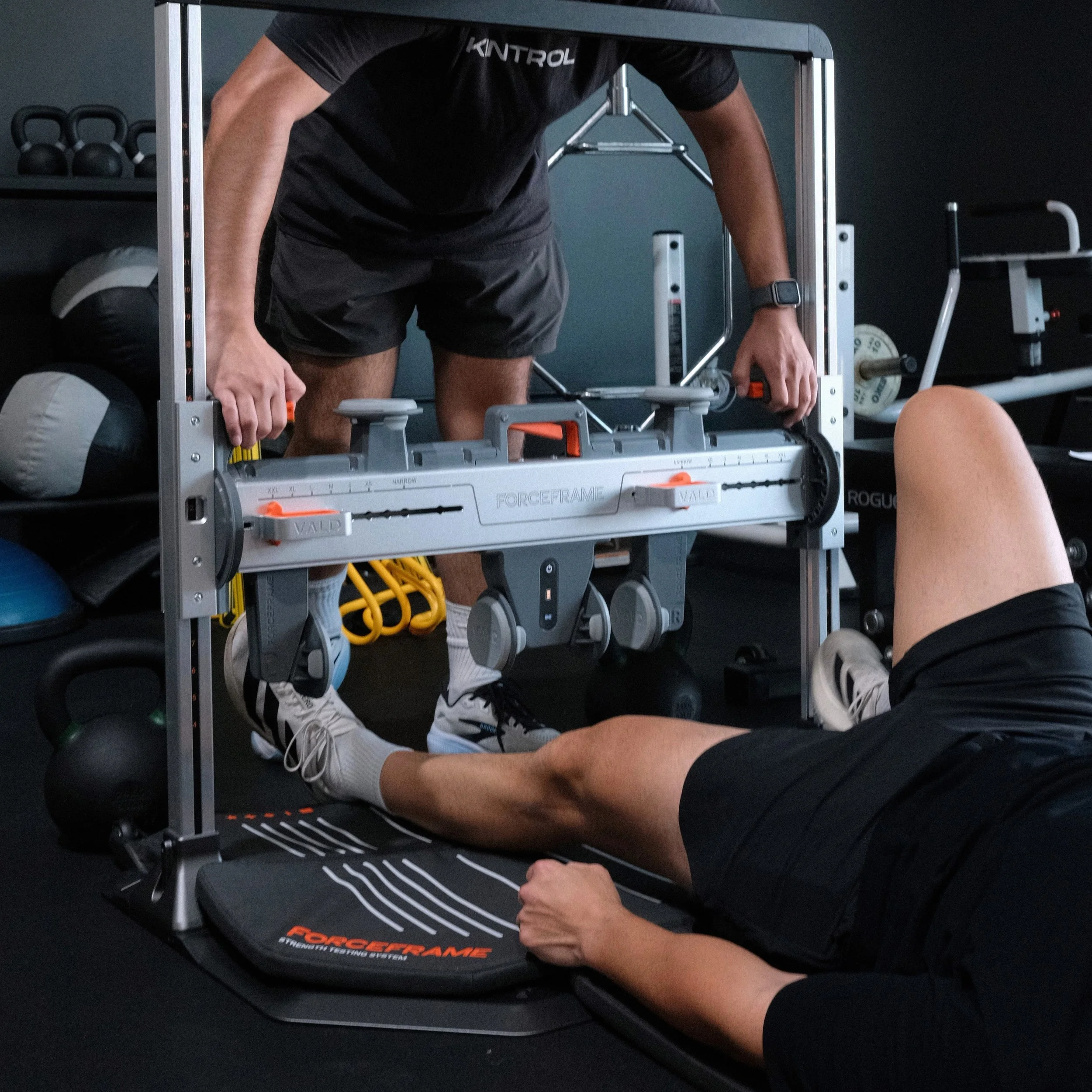 Athlete performing a seated leg press on a ForceFrame strength testing machine in a gym