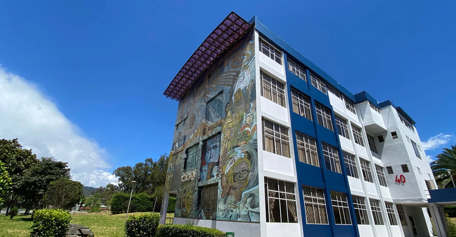 Edificio moderno con mural artístico en una ciudad de clima cálido.