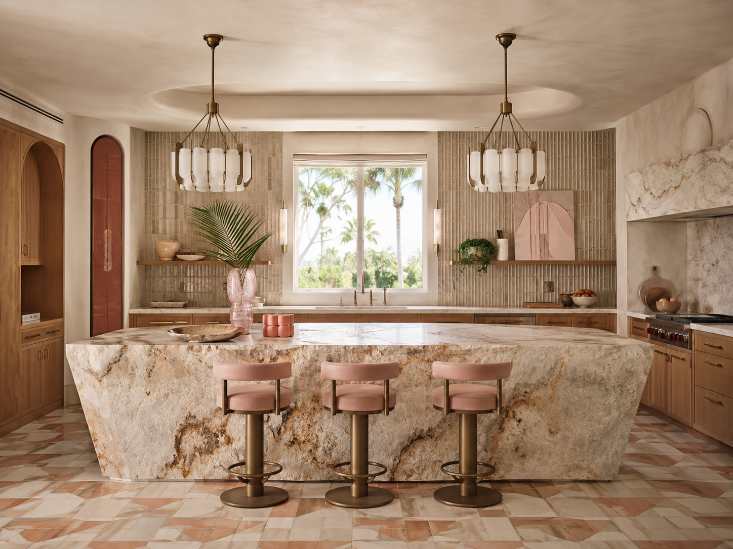 A modern kitchen with a large marble island, three pink bar stools, light wood cabinets, and a window overlooking palm trees.