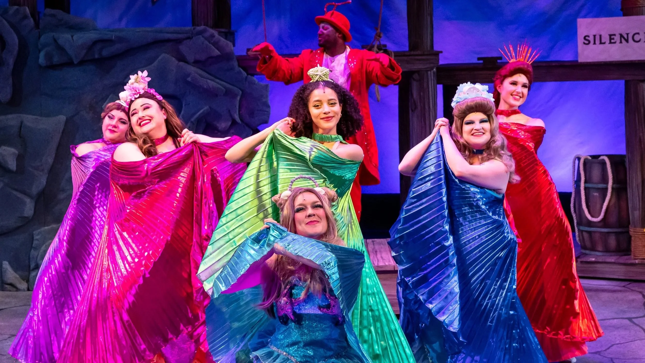 Musical Theatre production still from The Little Mermaid, featuring actor Meredith Aleigha Wells as Mersister Atina, looking radiant while dancing alongside the other mersisters in an under-the-sea set.