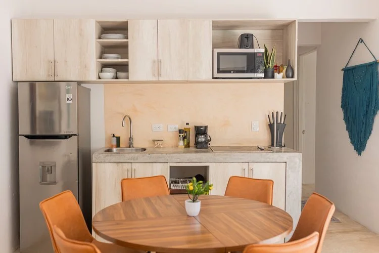 Real estate photography of modern kitchen with light wood cabinets, at Tulum.