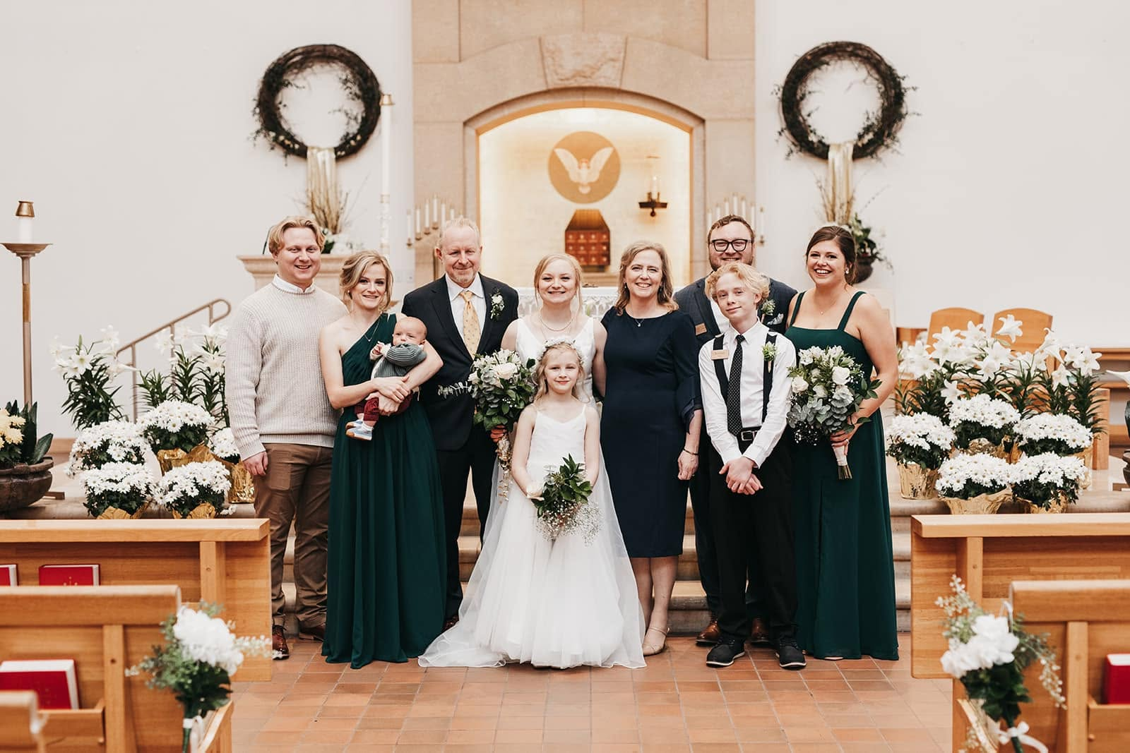 Brian and his family at a wedding ceremony in a church smiling for a photo.