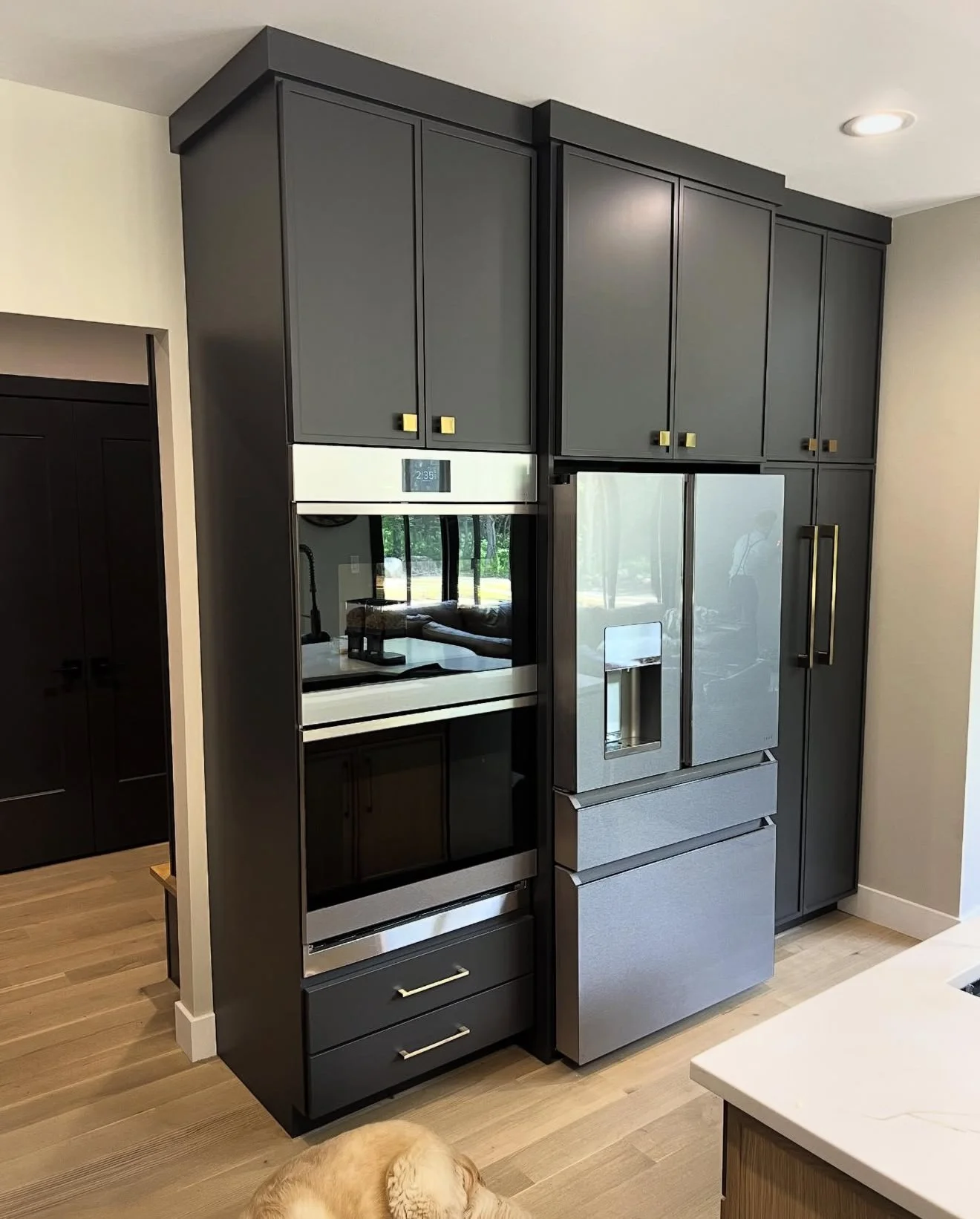 Custom dark gray pantry cabinetry with integrated refrigerator and built-in coffee station by EK Custom Cabinetry