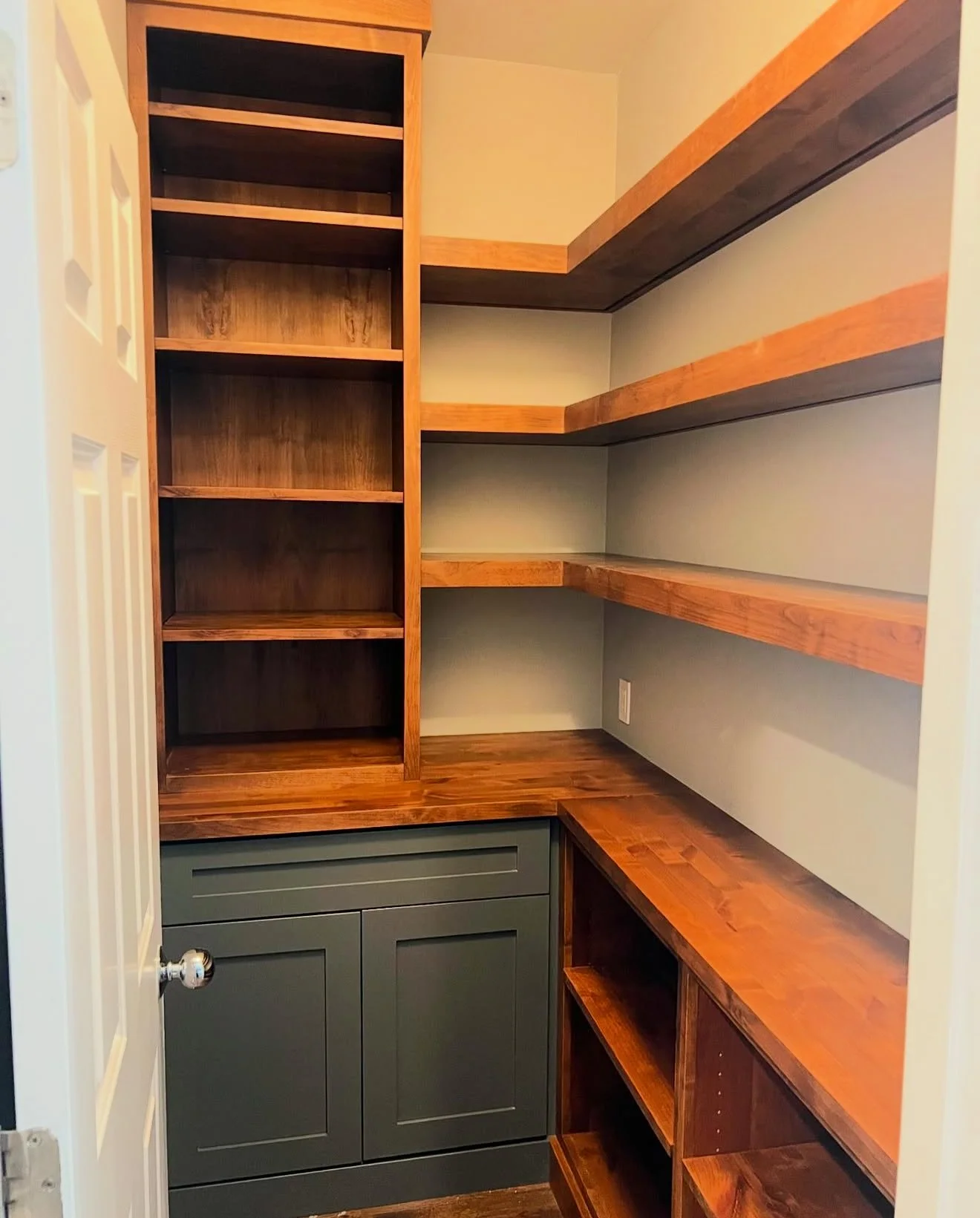 Custom walk-in pantry with floor-to-ceiling shelving, wood countertops, and built-in storage by EK Custom Cabinetry