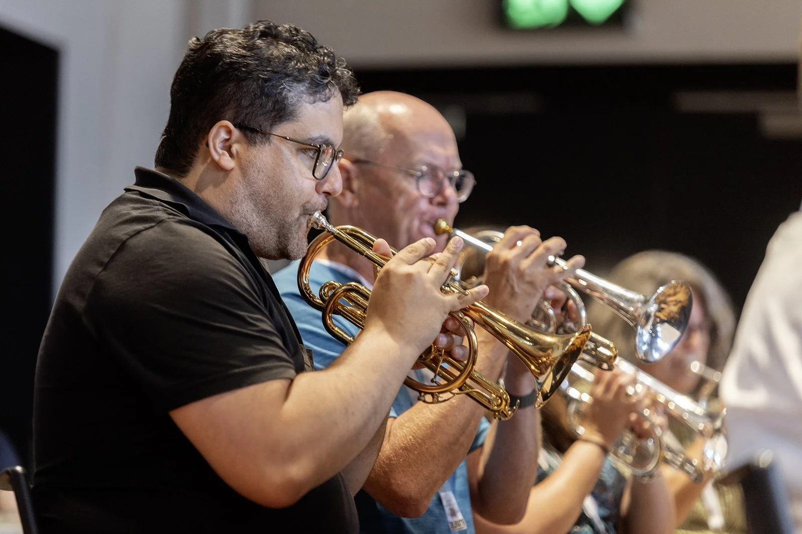 Group of musicians playing trumpets during a live performance.