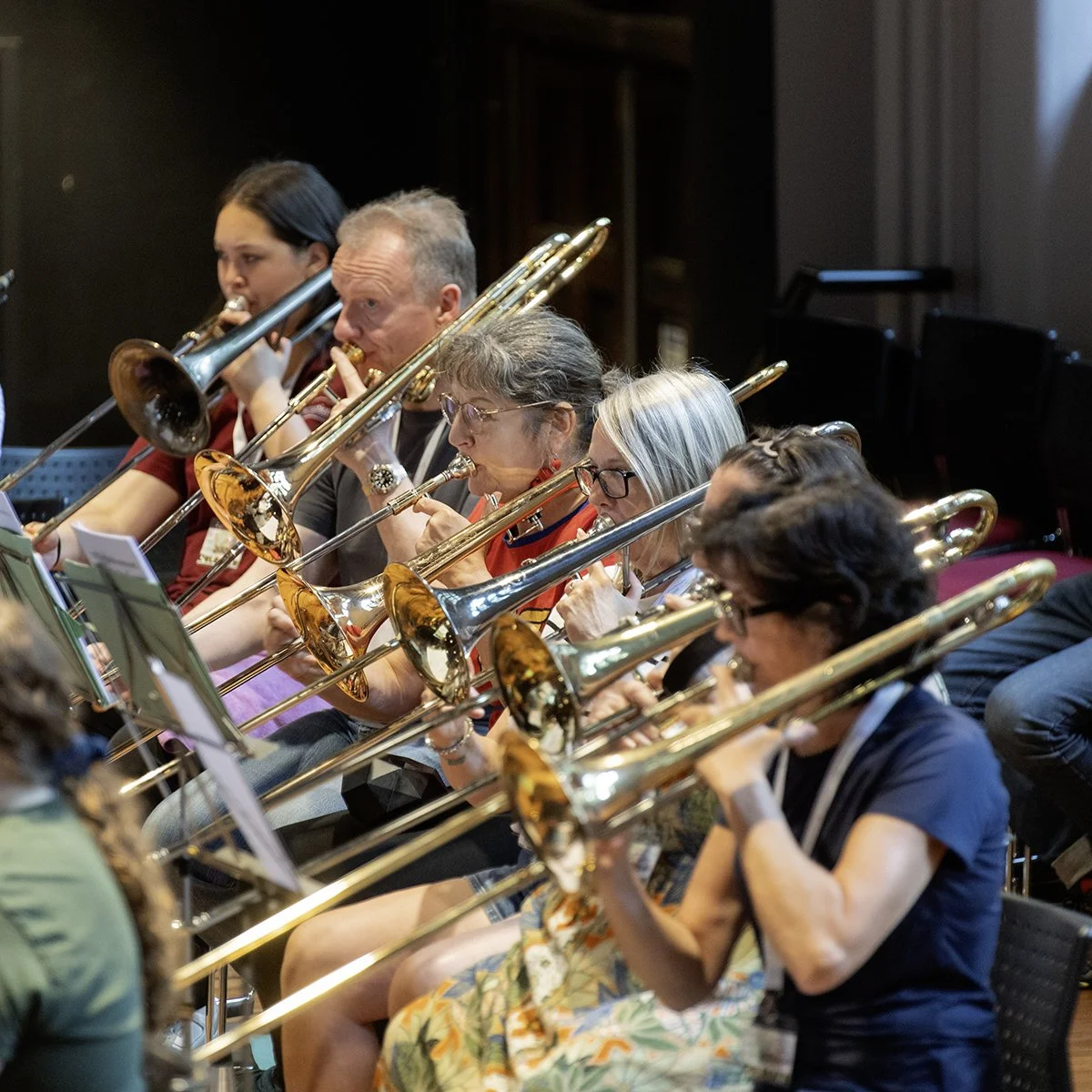 Group of musicians playing trombones during an orchestra rehearsal or concert.