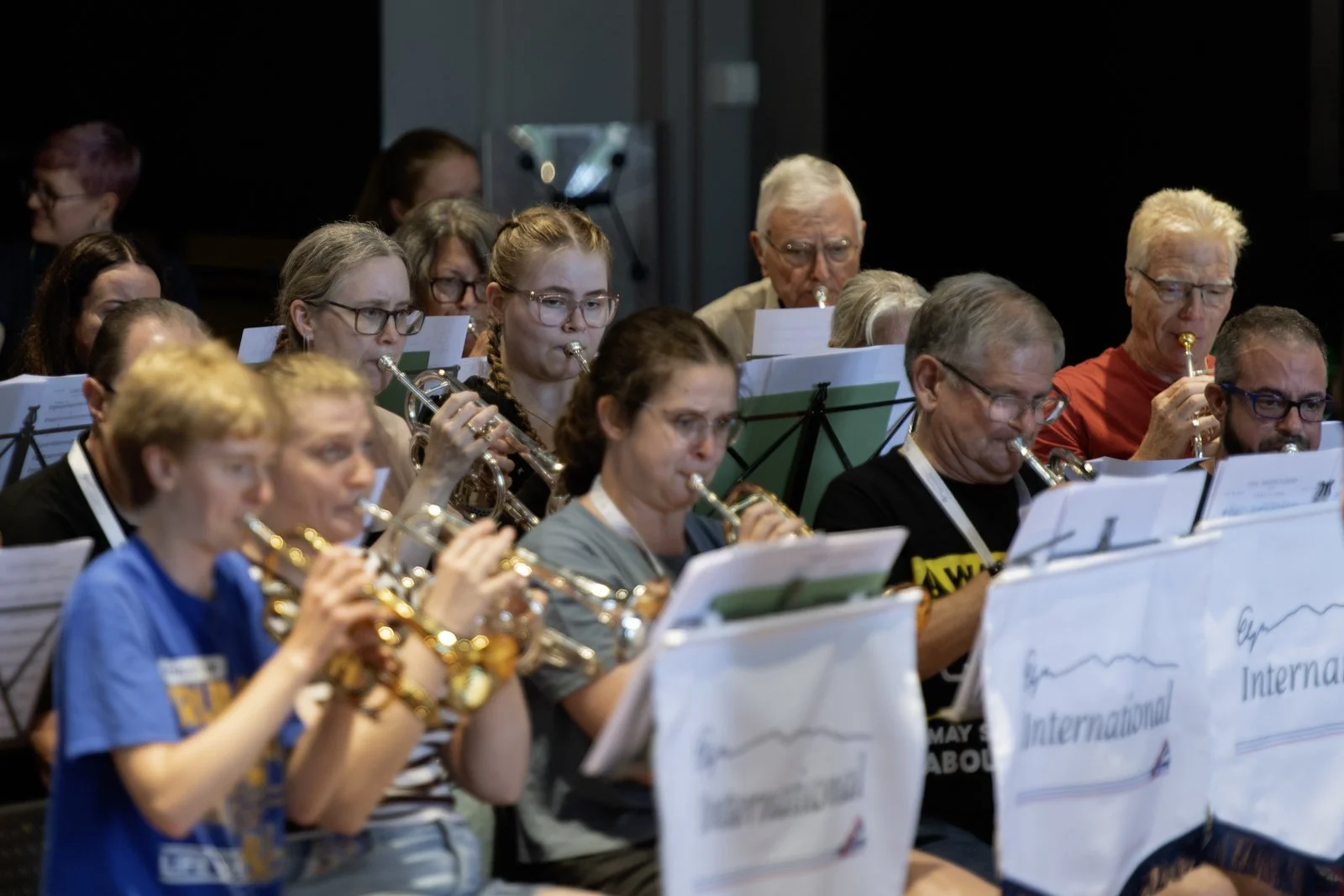 Group of people playing flutes in a band during a rehearsal or performance.