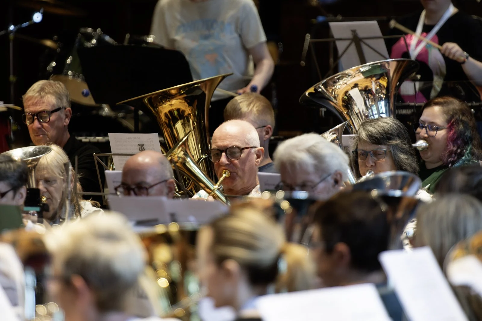 A group of musicians playing brass instruments during an orchestra performance.