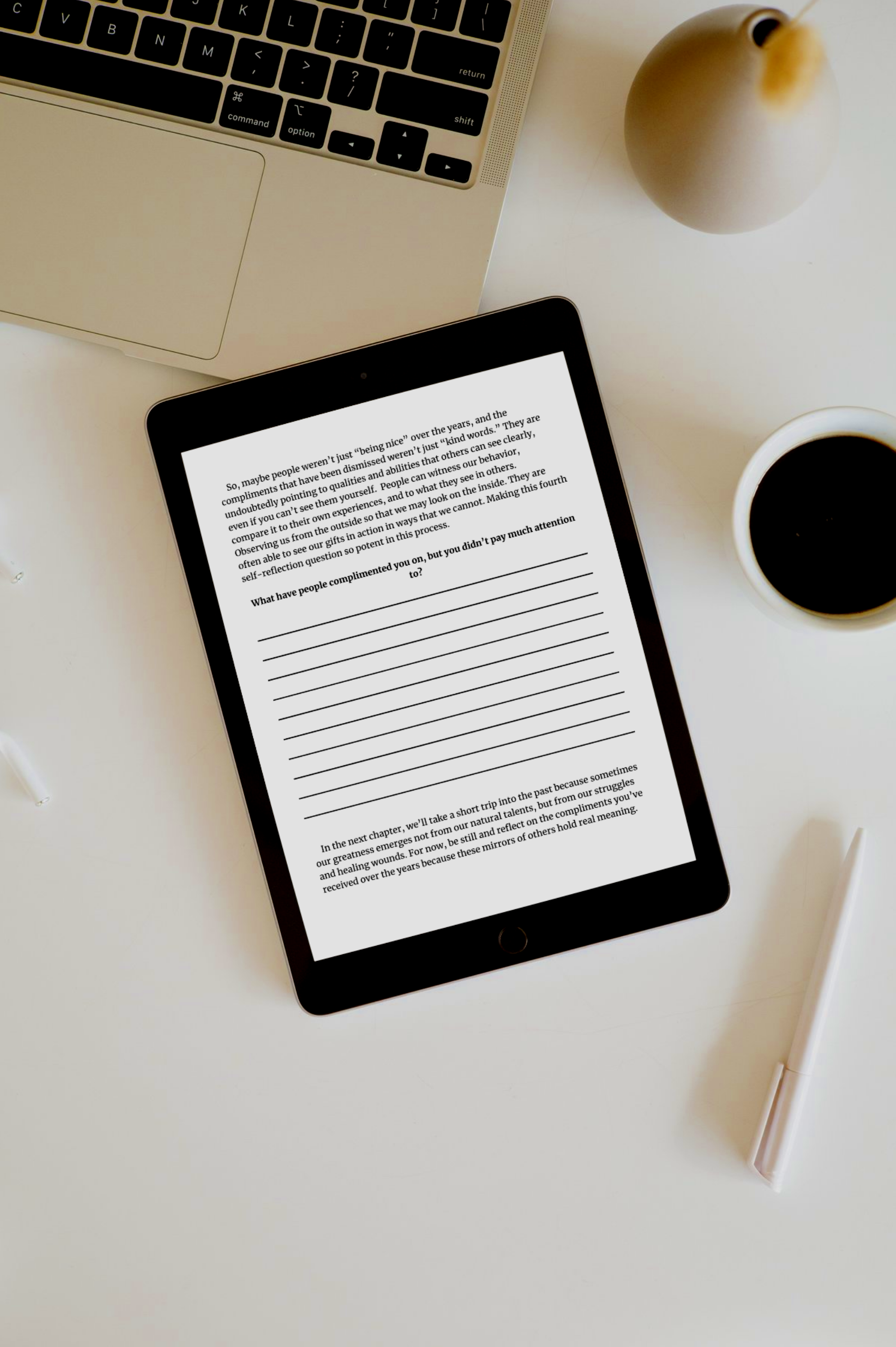 A workspace with a laptop, a tablet displaying text, a cup of black coffee, a white pen, and a white vase on a white surface.