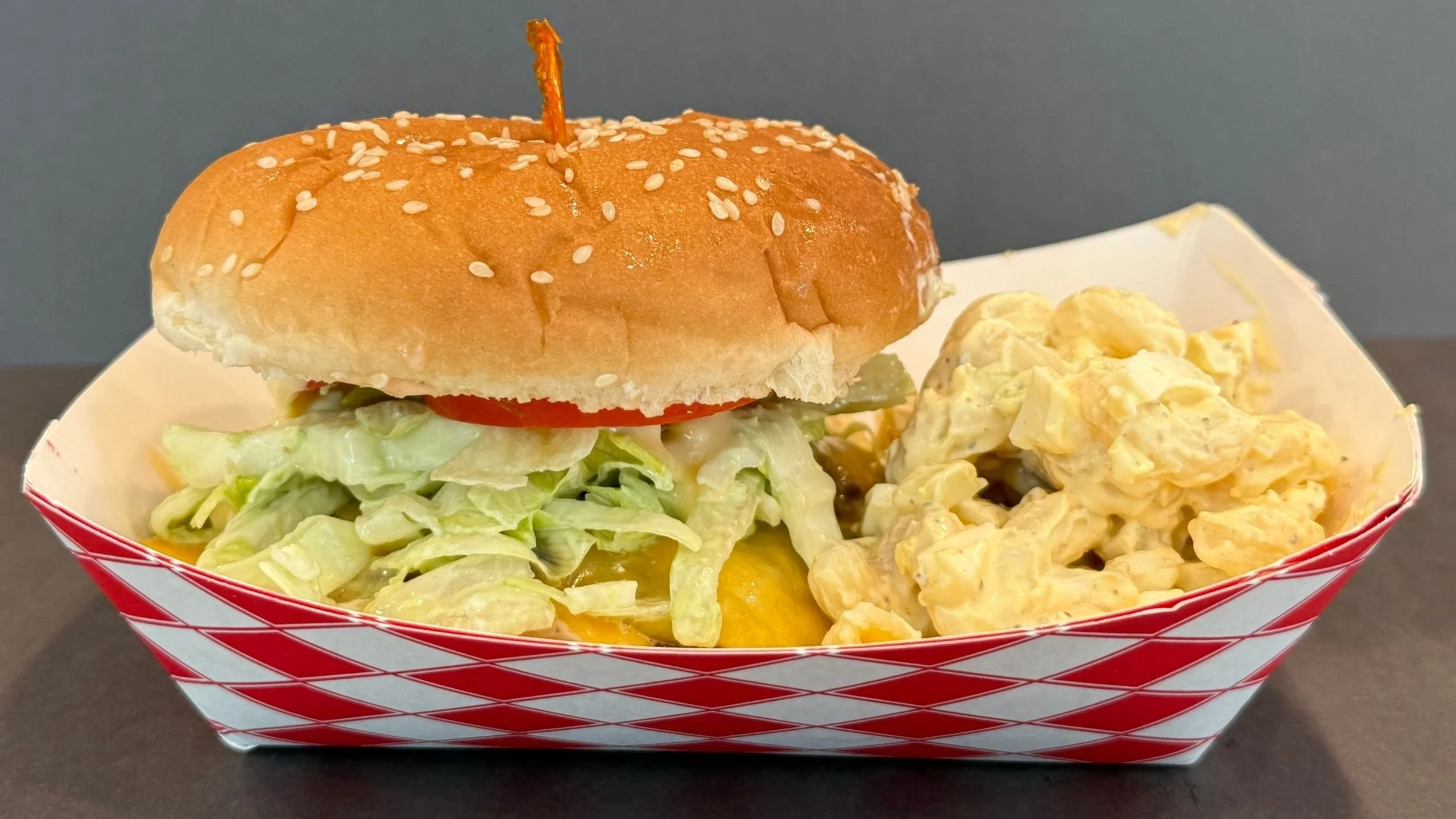 wagyu burger with fries in red and white paper basket