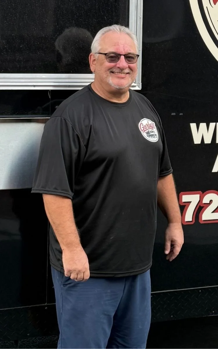 Man wearing Garby's food truck black shirt in front of truck