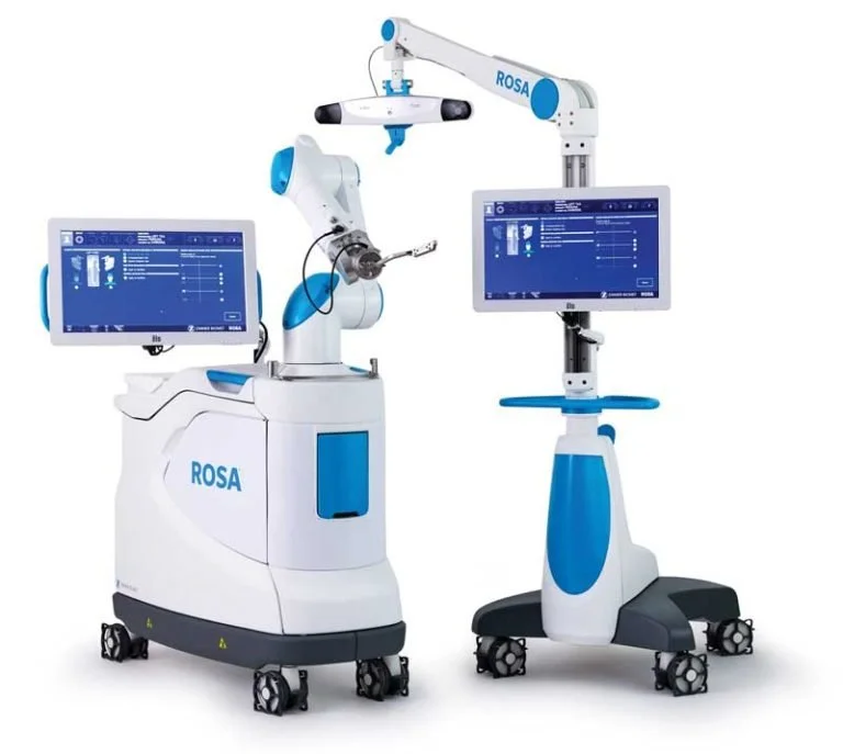 Equipo médico equipado con robots y pantallas digitales, probablemente para procedimientos quirúrgicos o de cirugía asistida.