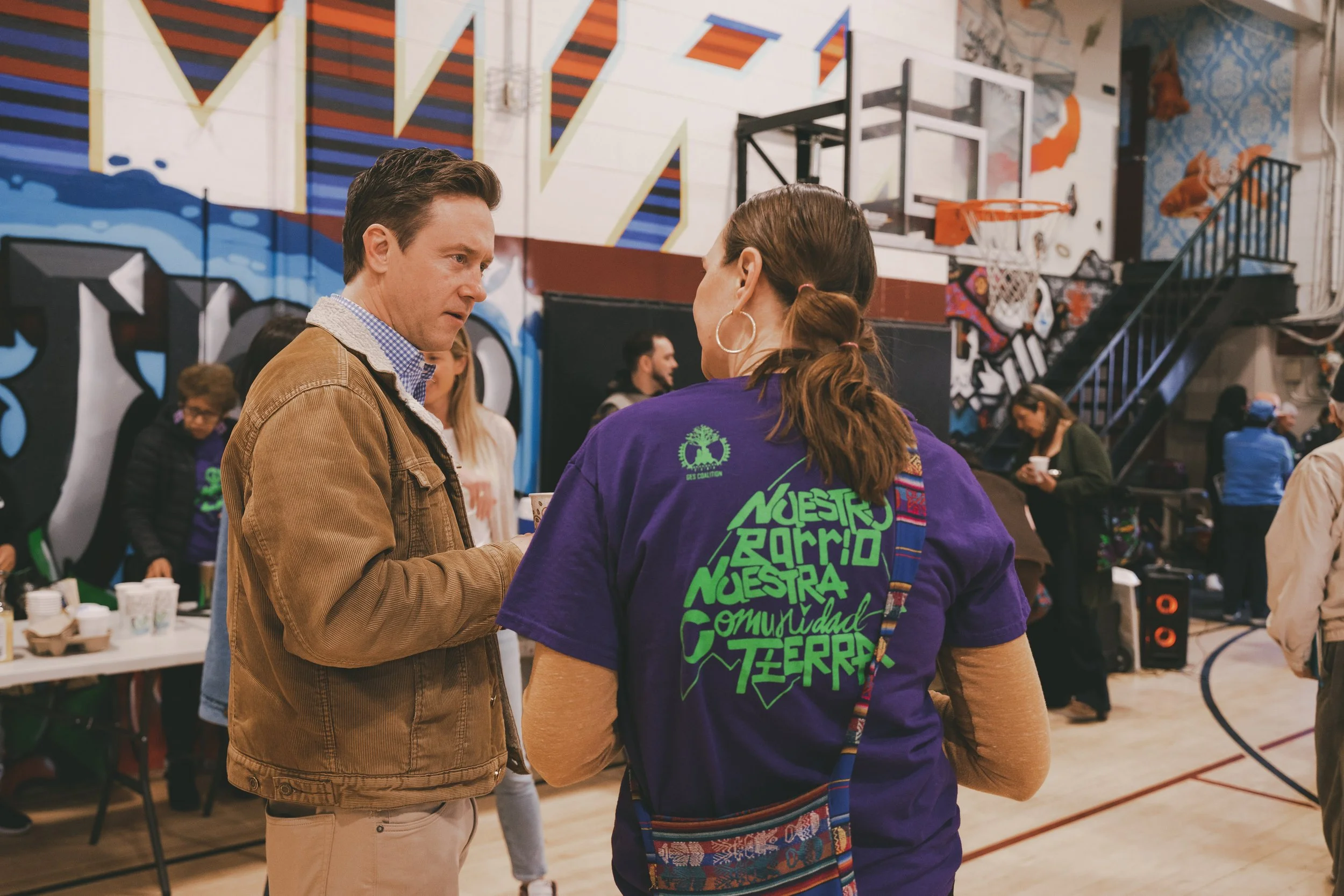 Nola Miguel of the GES Coalition, part of the 2026 Community-Owned Futures Cohort, speaks with Denver Mayor Mike Johnston at a community event. Photographer: AnthonyMvze.com