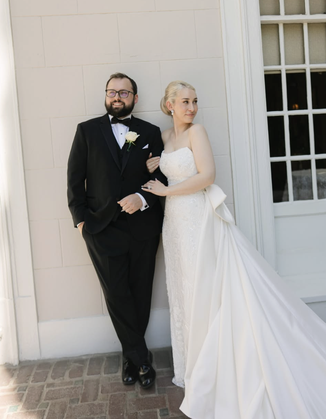 Laurie’s customers, Mariana and Carmen holding hands on a green lawn on their wedding day.