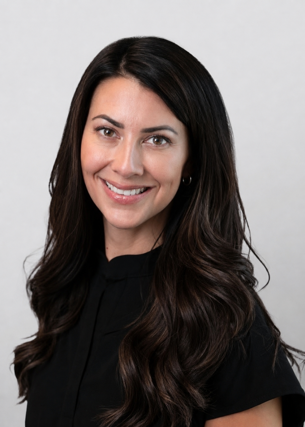 Professional portrait of Mallory Read, Family Practitioner and owner of Refined Beauty and Wellness, smiling, wearing a black top, against a plain white background.