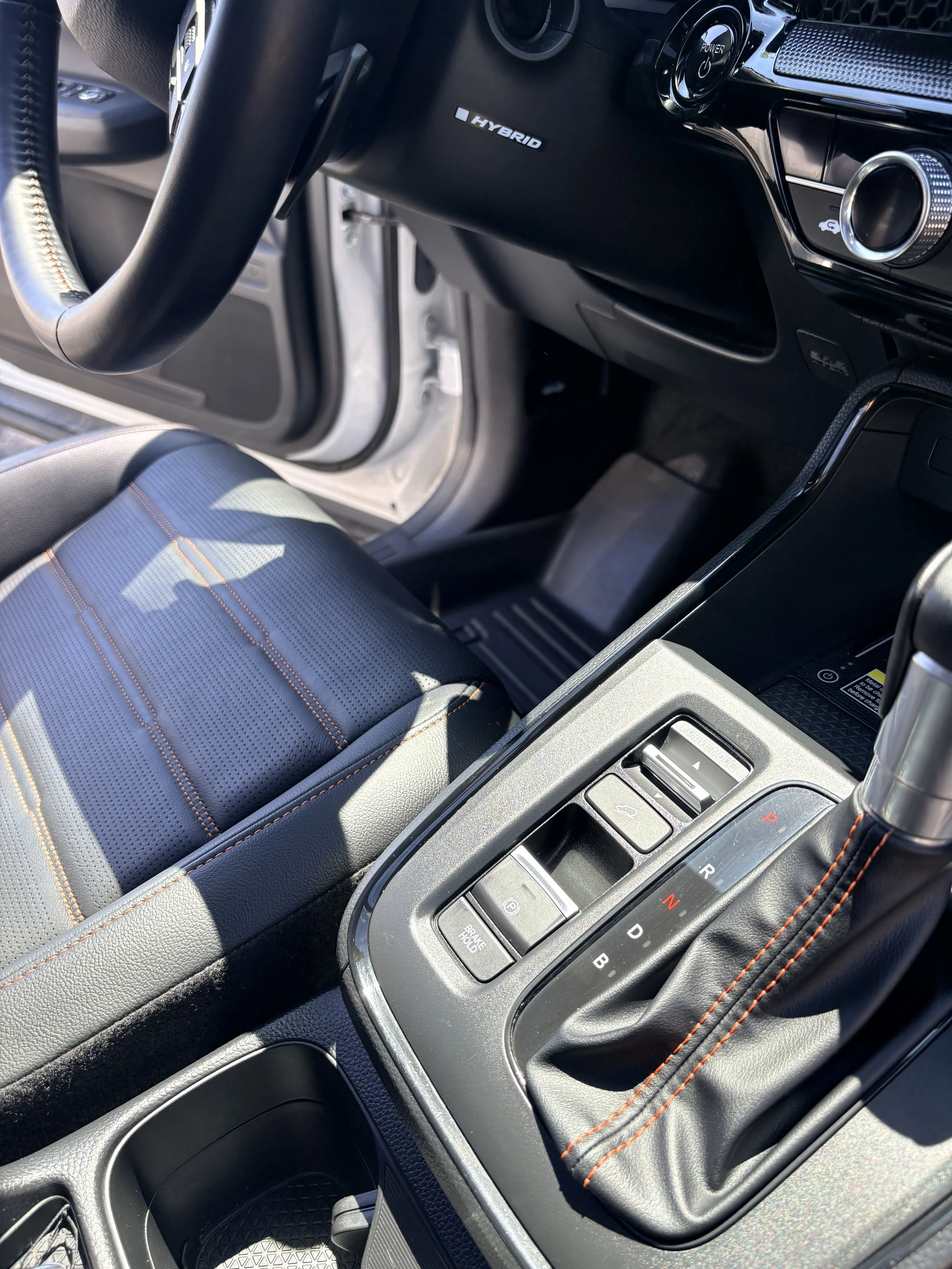 Interior of a hybrid car showing the gear shift, center console, and part of the steering wheel.