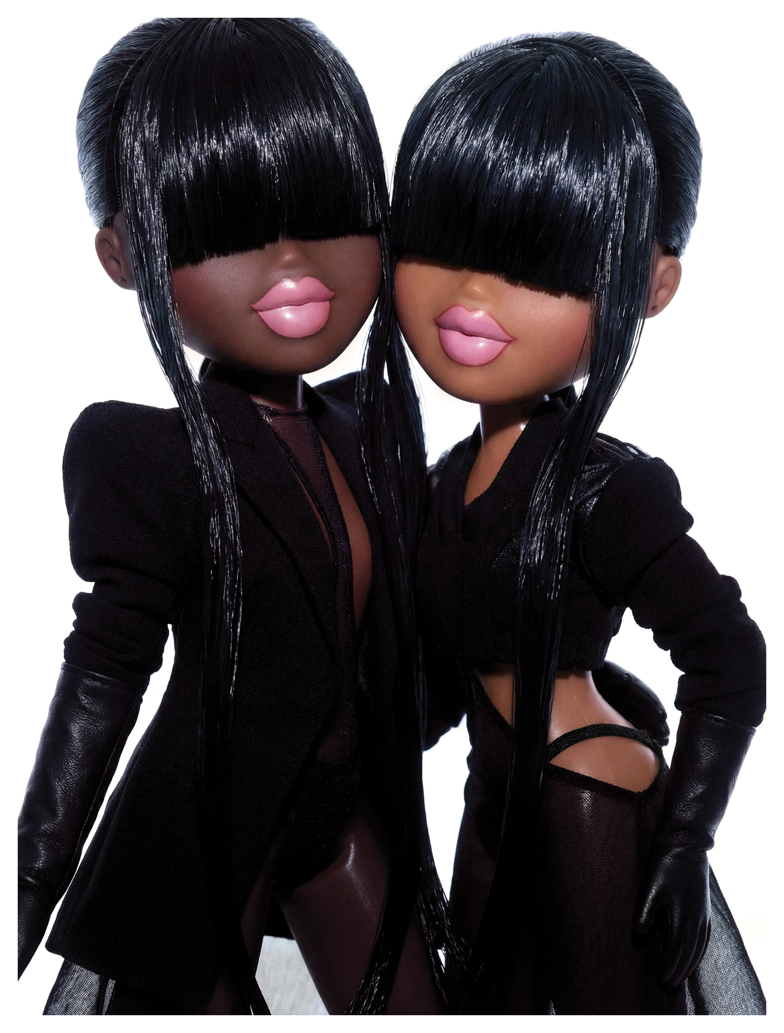 Two fashion dolls with black, shiny, long hair covering their eyes, wearing black outfits with gloves and stockings, posed against a white background.