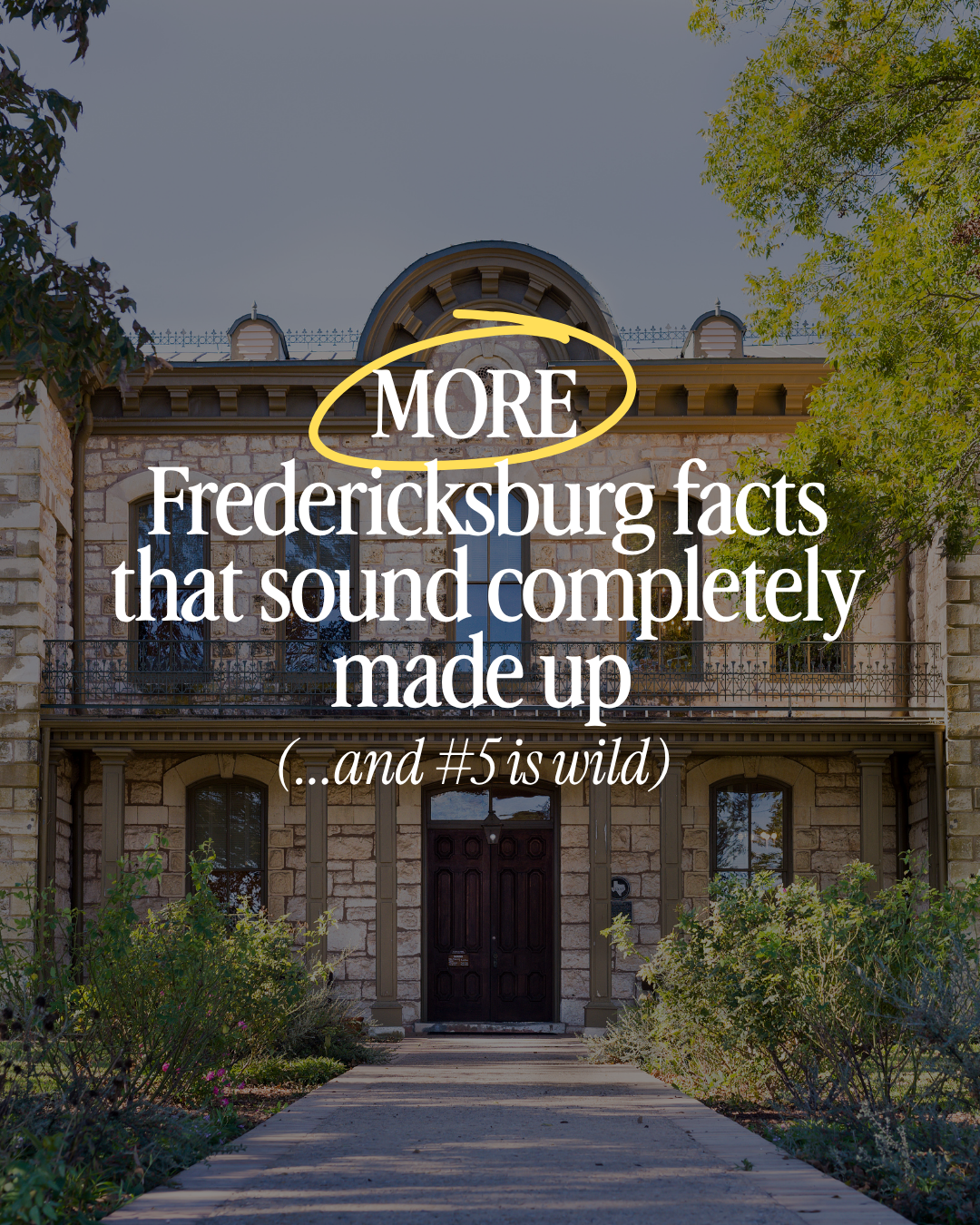 Historic stone house with arched windows, a wooden door, a balcony, and surrounding greenery in Fredericksburg.