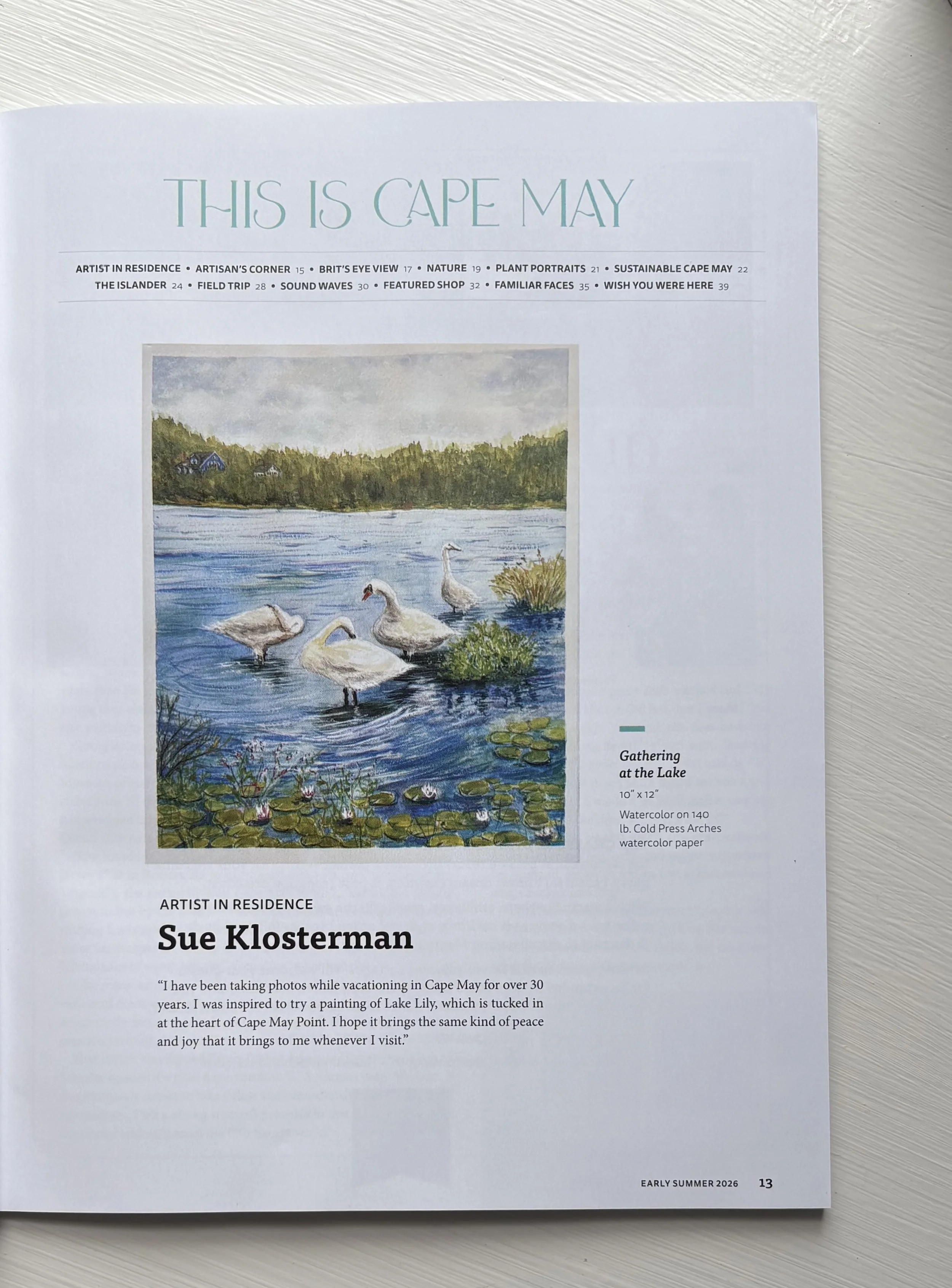 Page from a magazine or brochure titled "This is Cape May" featuring a watercolor painting of a lake with swans, lily pads, and greenery. The page includes artist information, Sue Klosterman, and a quote about her inspiration from Cape May.