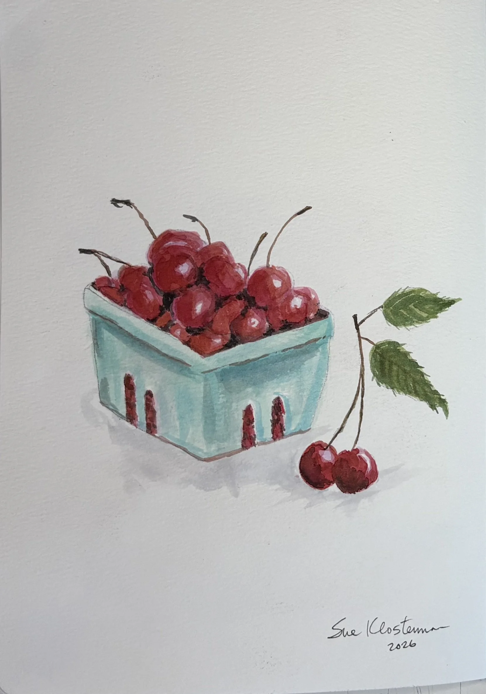 Watercolor painting of a blue container filled with red cherries, with two cherries and green leaves placed outside to the right, and an artist's signature and date at the bottom right. Journal painting of cherries using liquid watercolors