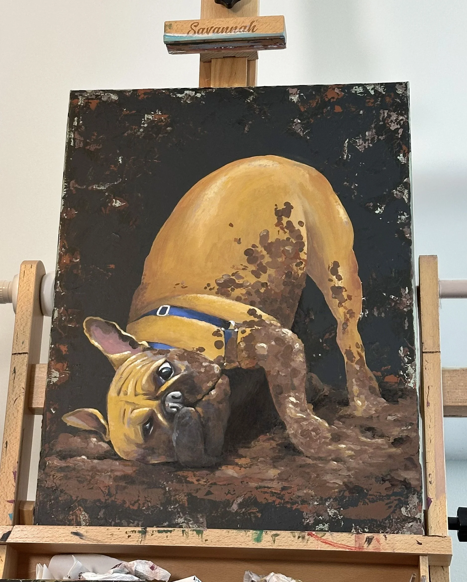 Playful painting of a dog with blue harness, rolling in the mud with a black background and orange highlights.