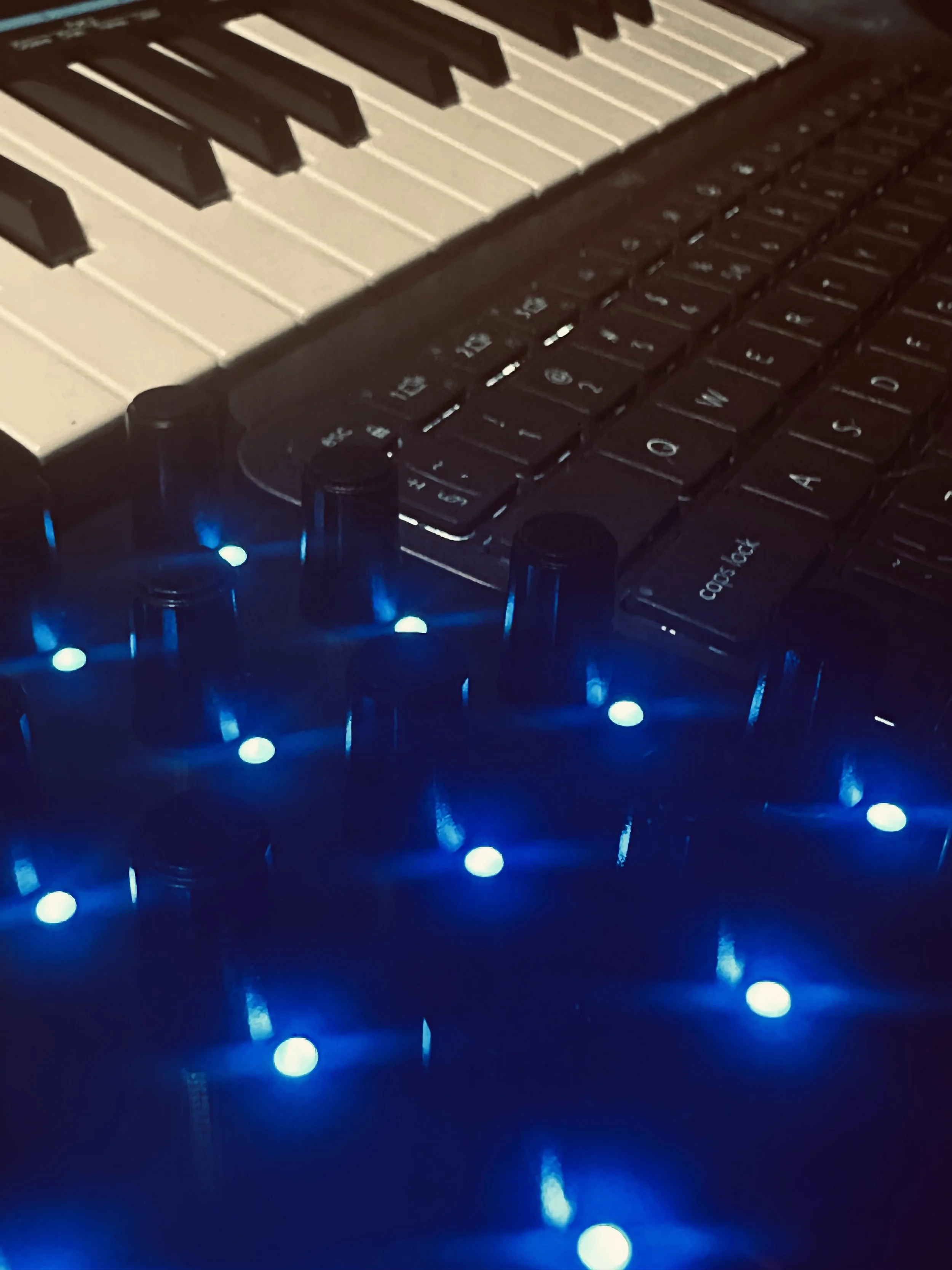 Close-up of a black and white keyboard with blue LED lights underneath.