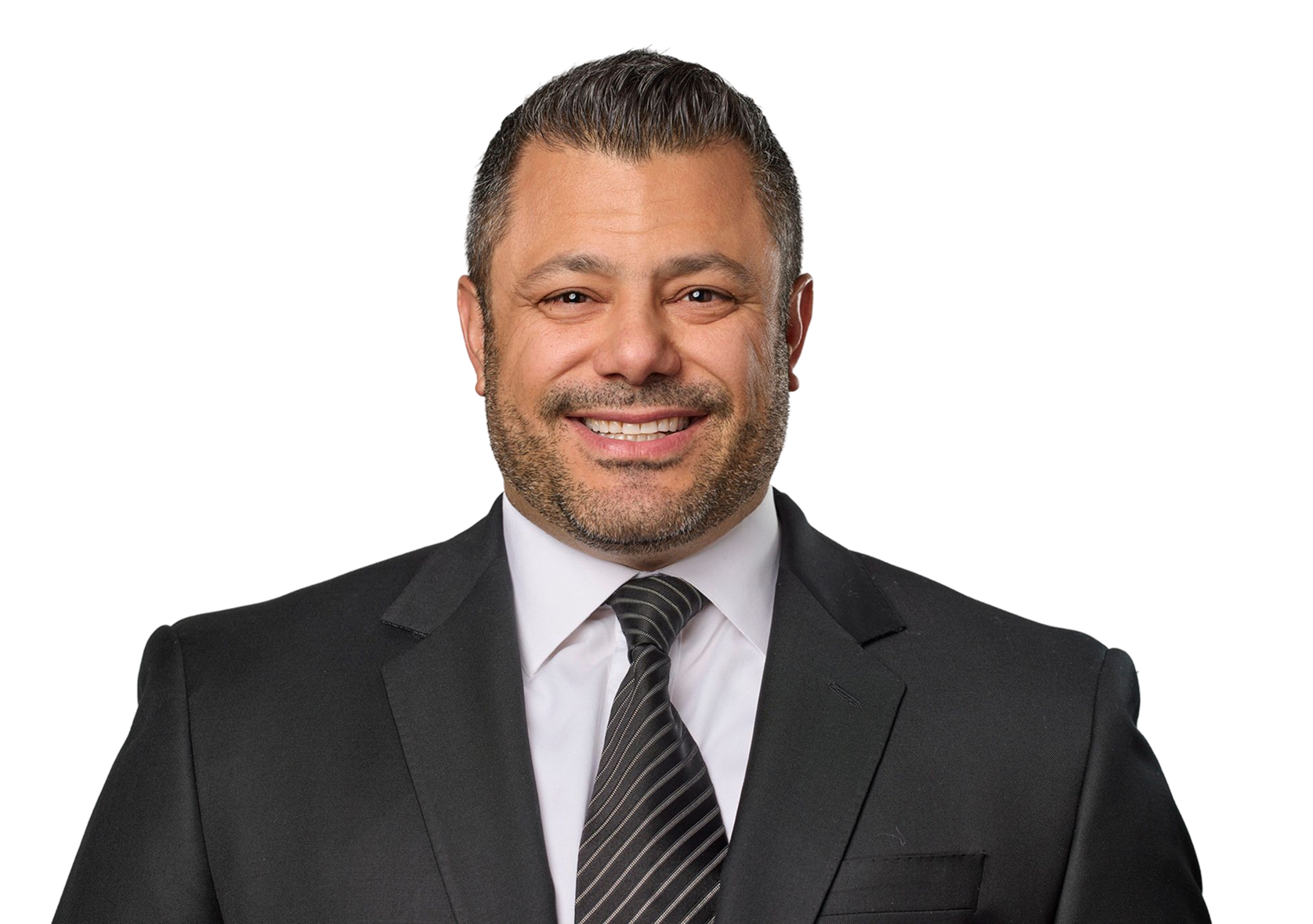Smiling man in a black suit, white shirt, and striped tie standing against a black background.
