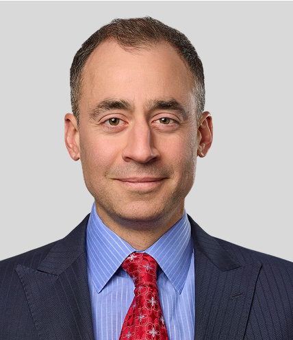 Professional man in a suit and red tie posing for a portrait.