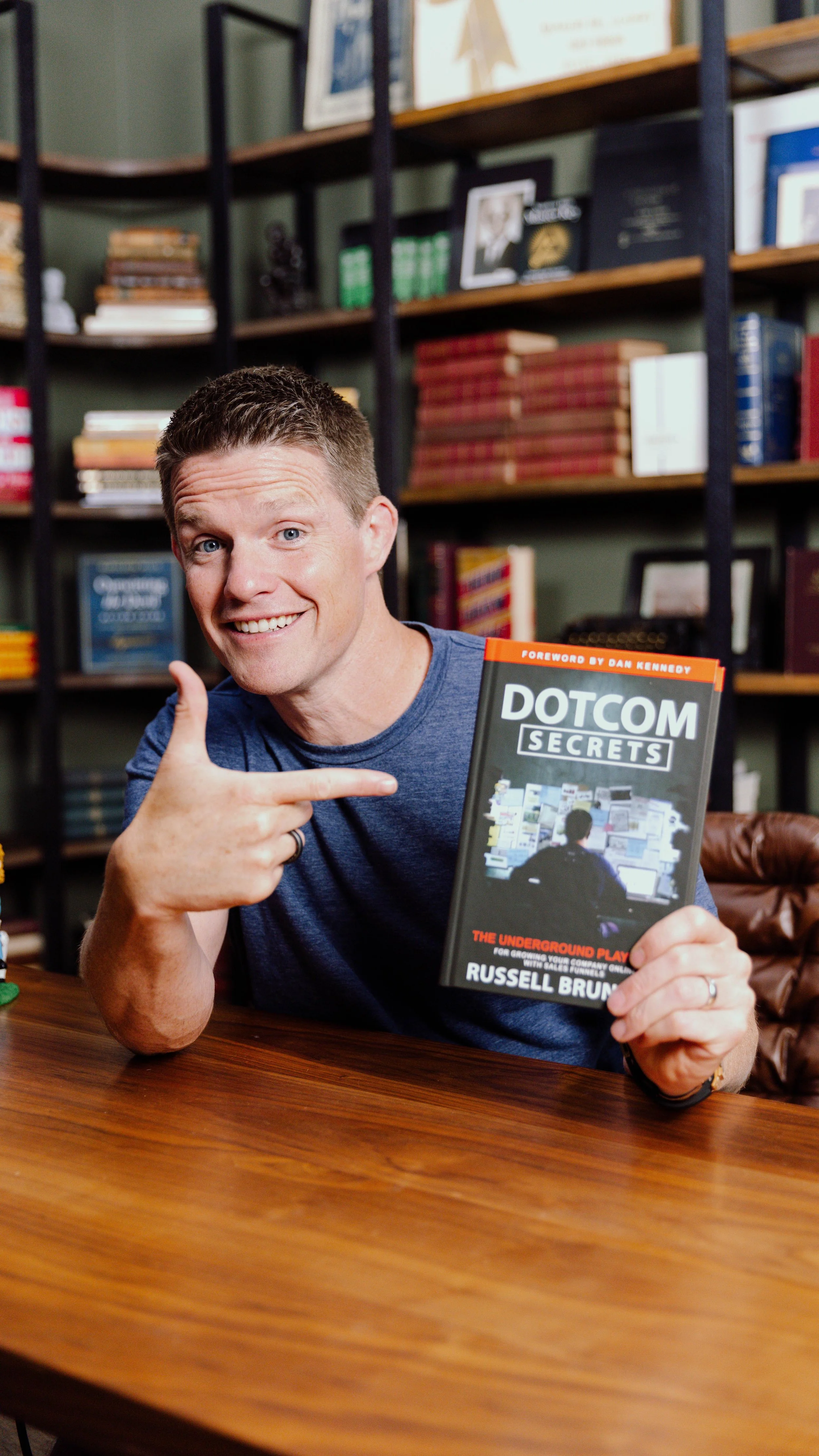 Russell Brunson holding his book DotCom Secrets