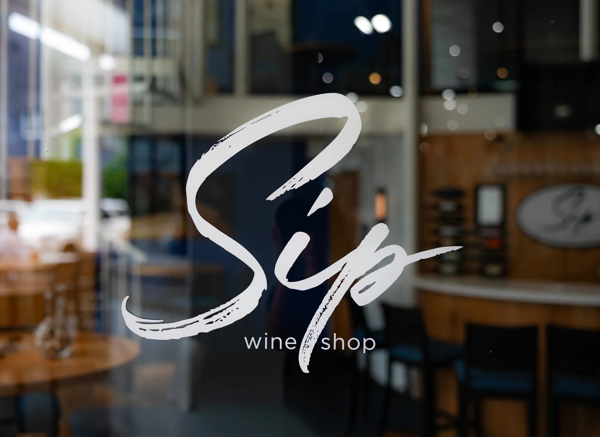 Front sign image glass reads Sip Wine Shop