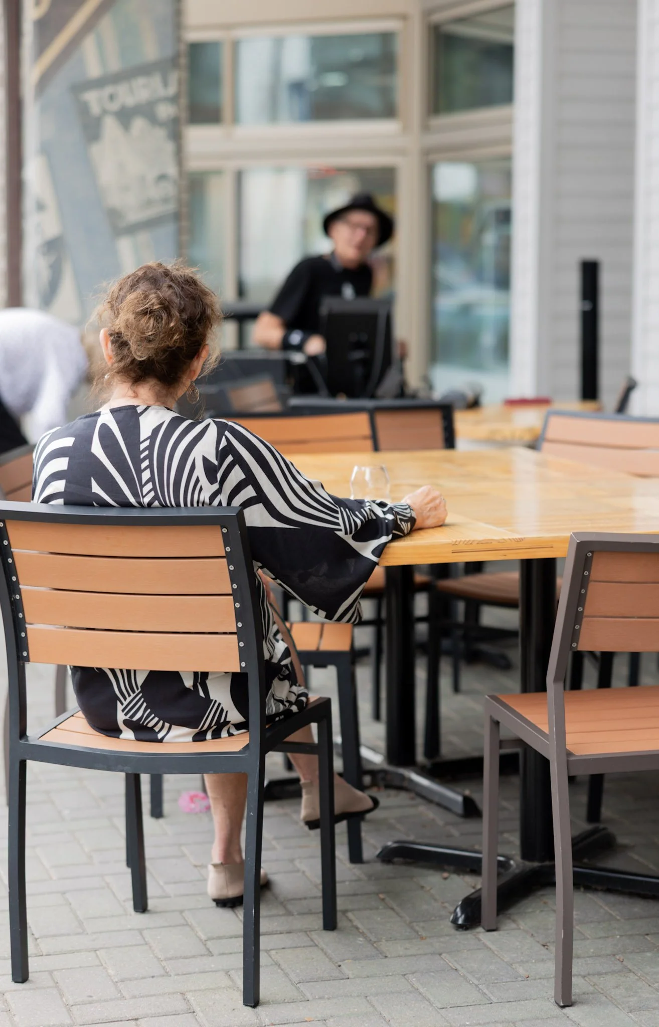 Woman enjoying music and wine at Sip’s outdoor sidewalk seating in Bay Harbor