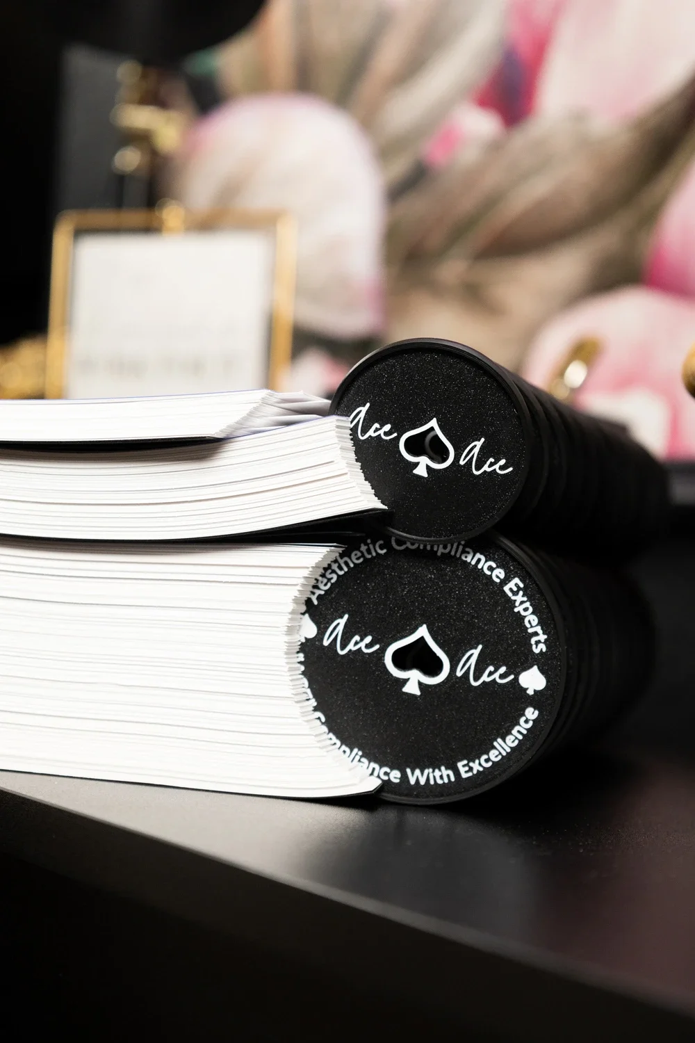Close-up of disc-bound manual with black ends marked by white spade symbols and “Compliance With Excellence."