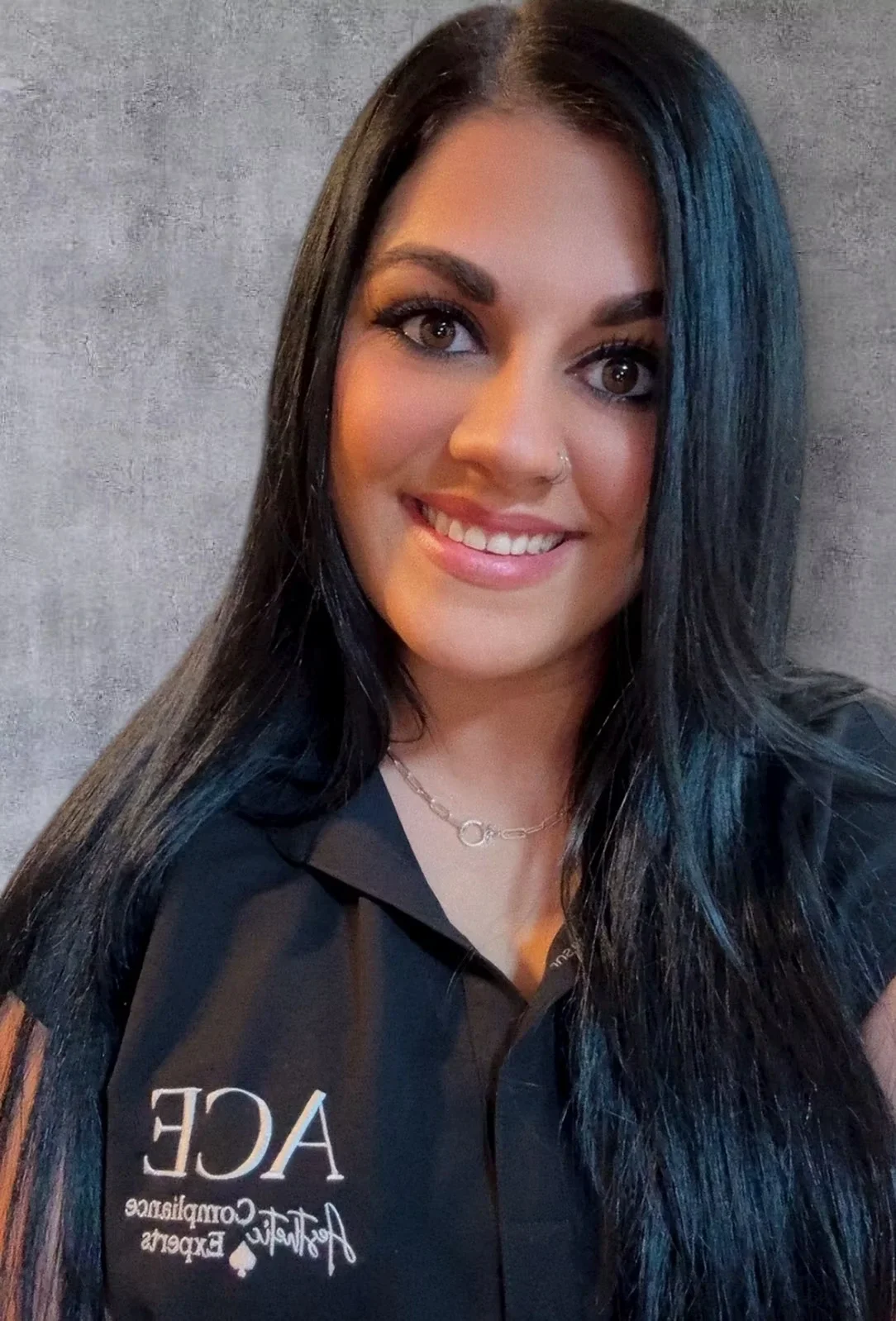 Smiling woman with long dark hair poses in a black ACF shirt.