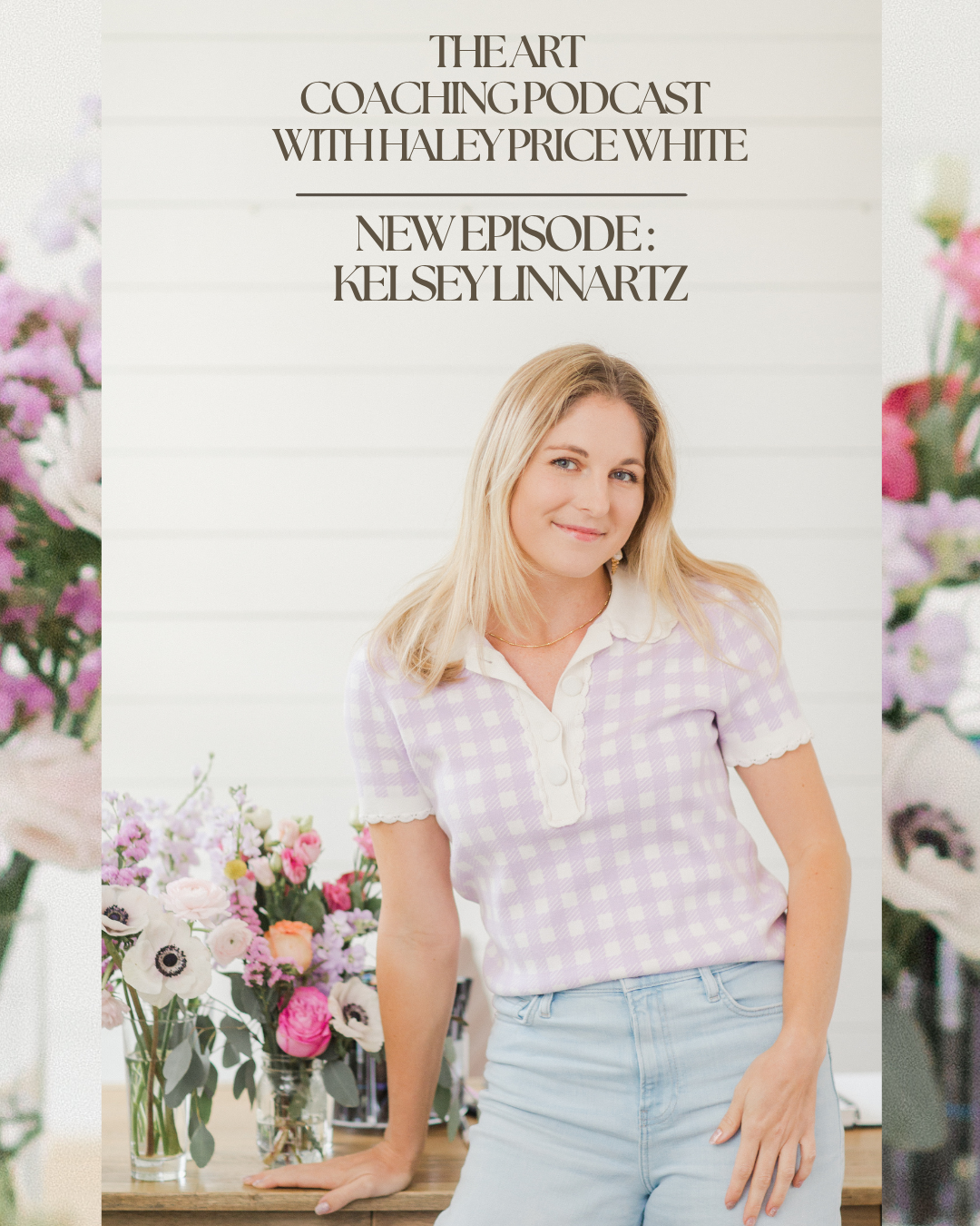 A woman with blonde hair wearing a lavender and white checkered shirt and light blue jeans, standing next to a table with a bouquet of pink and white flowers, smiling.