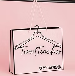 A pink sign with black border and text that says 'Tired Teacher' and 'Cozy Classroom,' hanging from a hand-shaped hook.