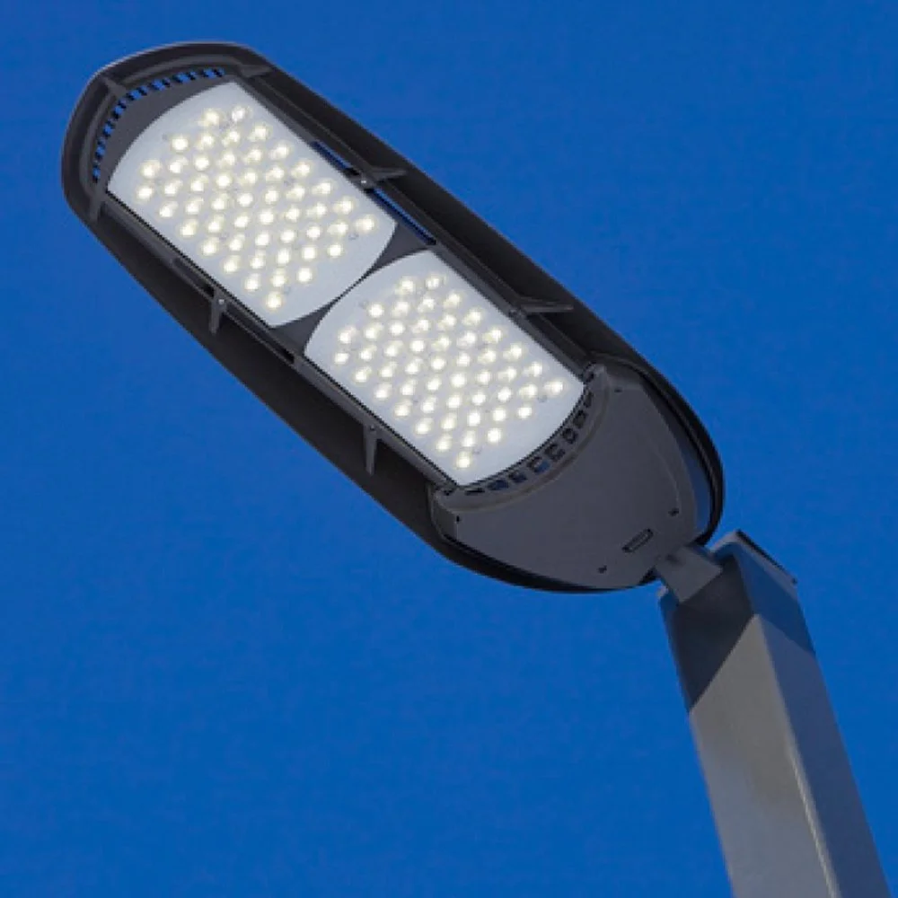 Close-up image of an LED streetlight against a clear blue sky.