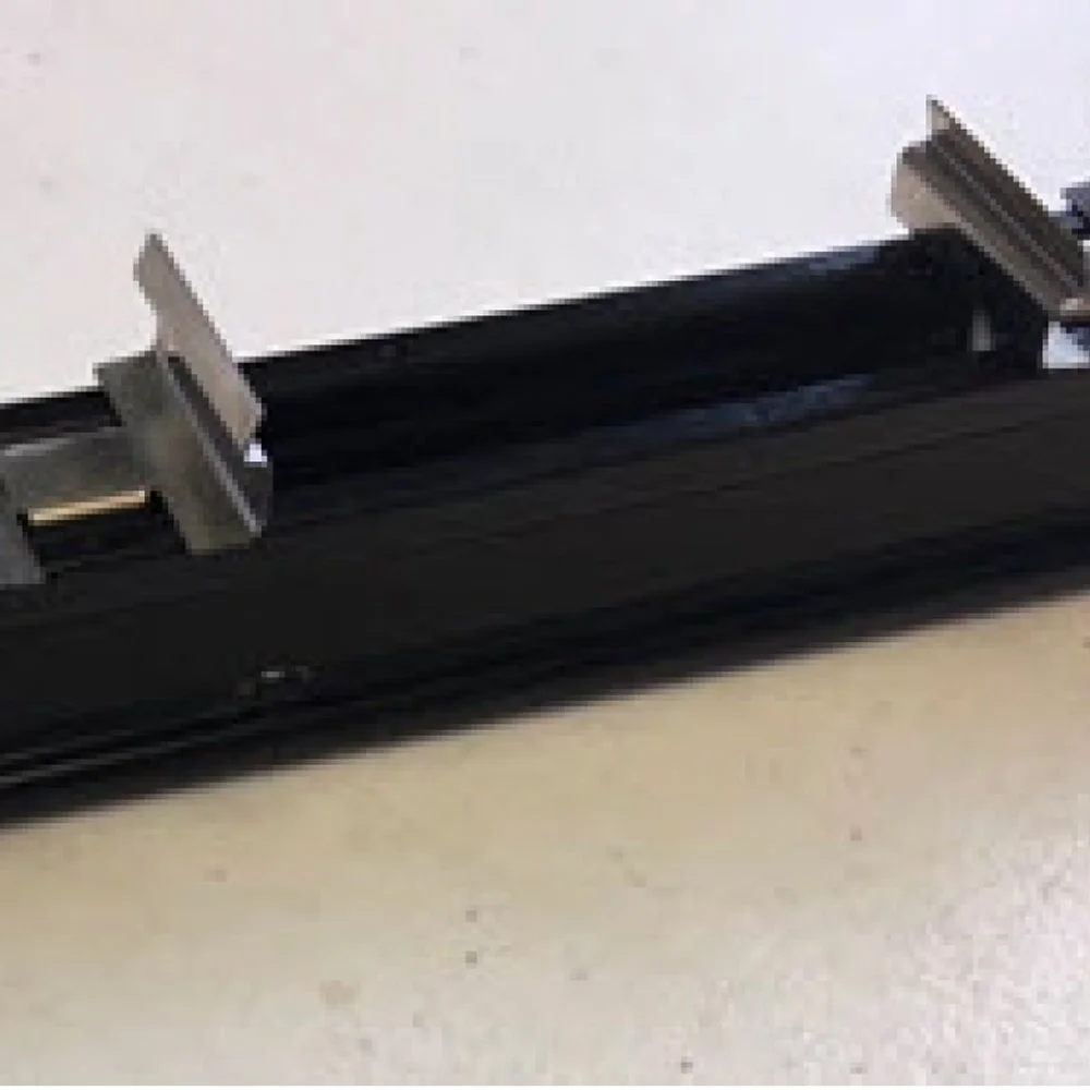 Close-up of a black trackless paper cutter with metal clamps